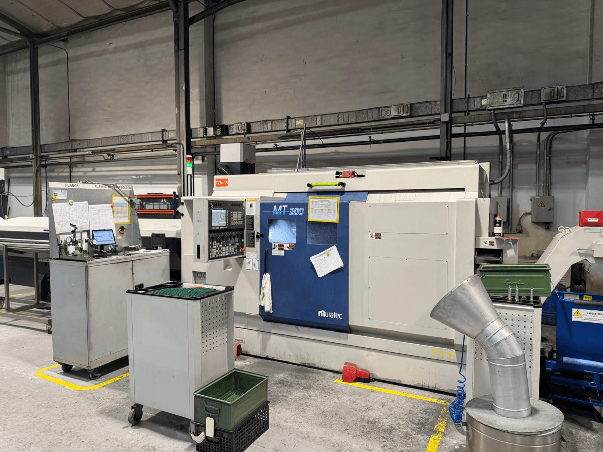 Muratec MT200 -monikarainen sorvauskone tehdasympäristössä edestä katsottuna, ohjauspaneeli ja ympäröivät laitteet.