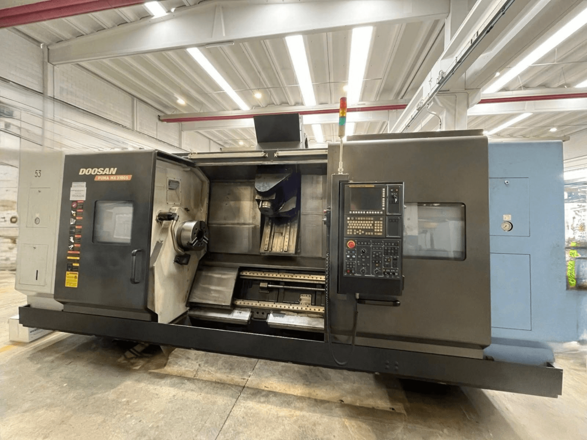 DOOSAN PUMA MX3100 -vaakakaraisen sorvin etunäkymä, jossa näkyvät ohjauspaneeli sekä karan ja työkalunpitimen alue.