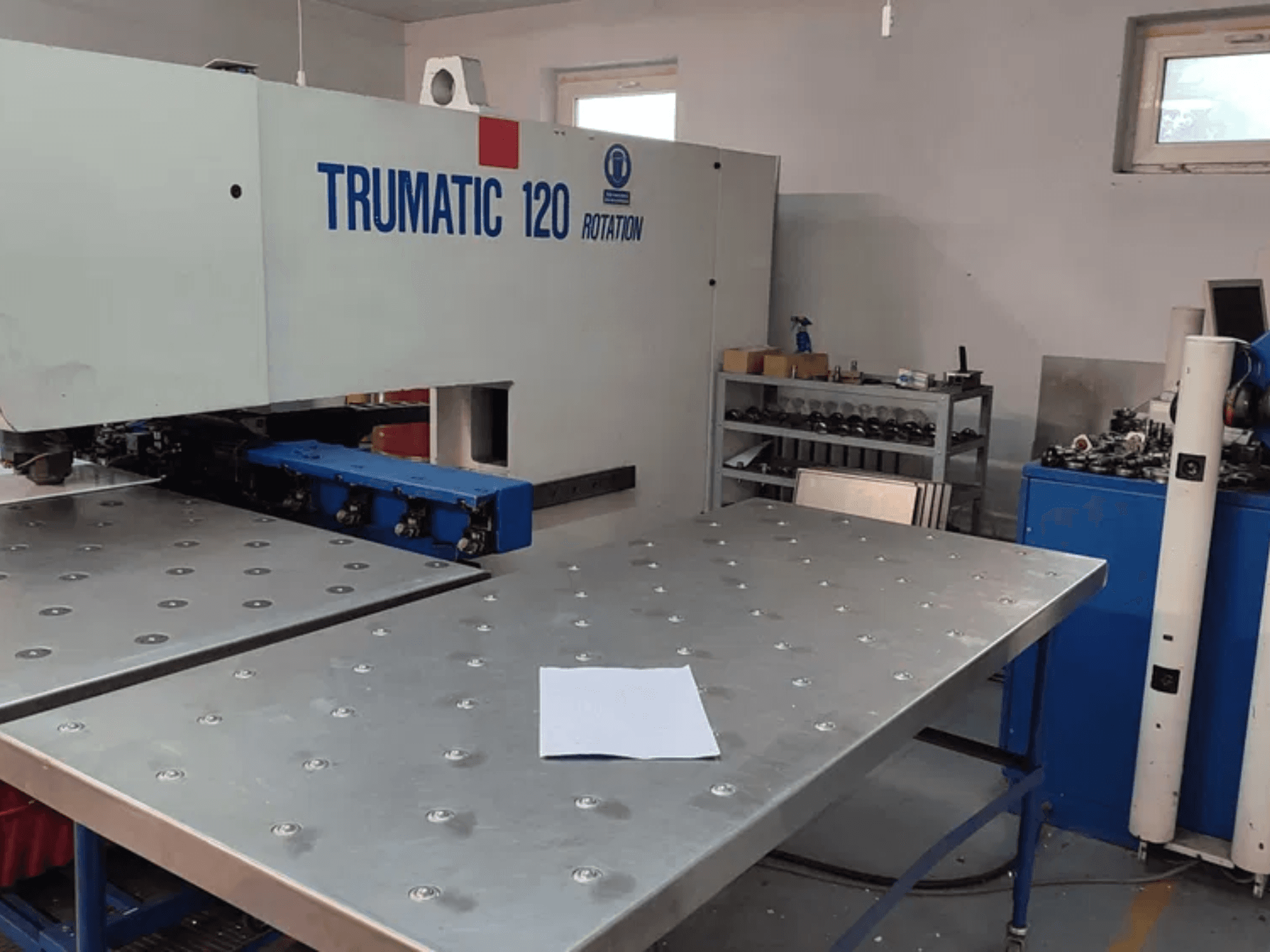 TRUMPF TRUMATIC 120R CNC-lyöntikone edestä katsottuna, jossa on metallipöytä, jossa on reiät ja tyhjä levy.