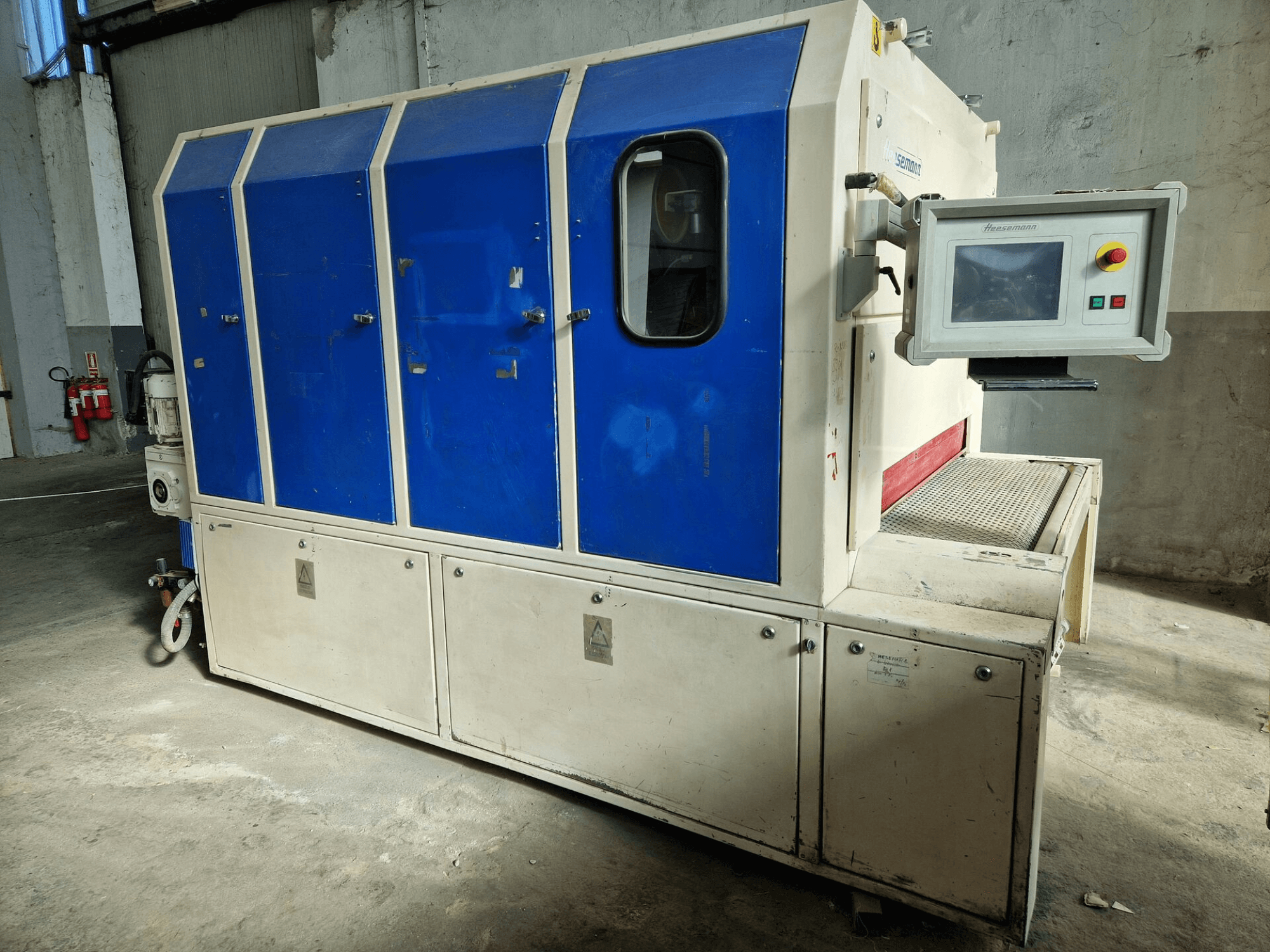 Sedecom-merkin teollisuuskone, sivukuva; siinä on siniset paneelit, ohjausnäyttö ja kuvioitu pinta tuotteiden käsittelyä varten.