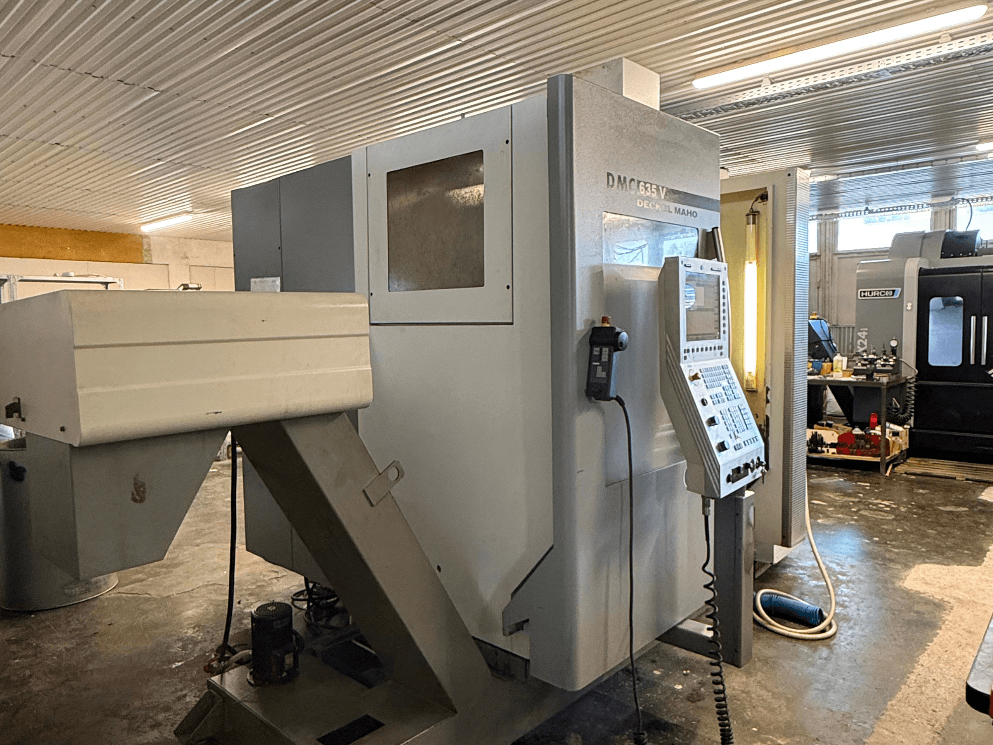 DMC G635V -jyrsinkone työpajassa, etukuva, jossa ohjauspaneeli ja liitetyt sähkötyökalut näkyvissä.