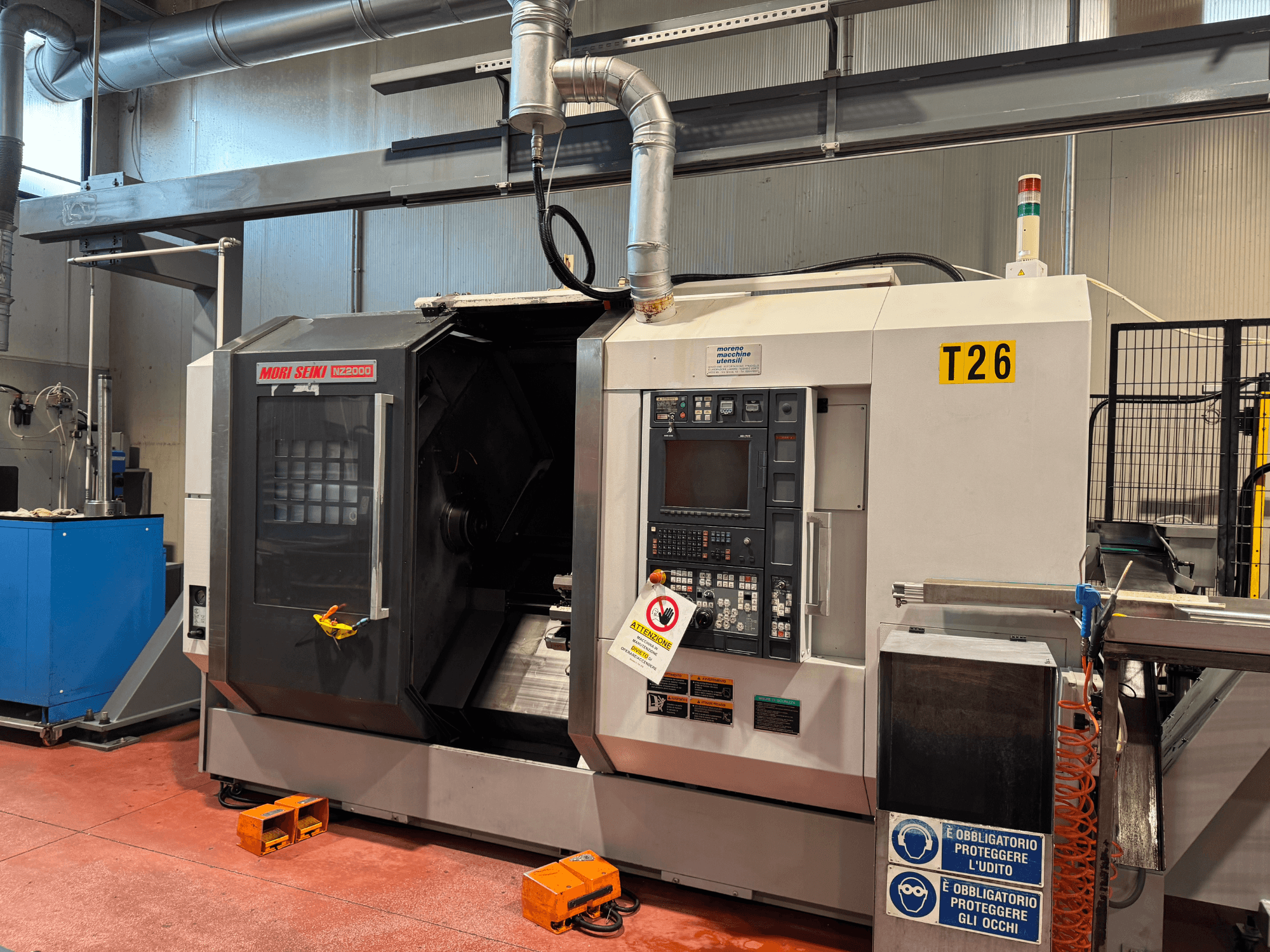 MORI SEIKI NZ-2000/T2/Y2 -kääntökeskus, etukuva, jossa on ohjauspaneeli, turvamerkinnät ja teollisuusasennus.