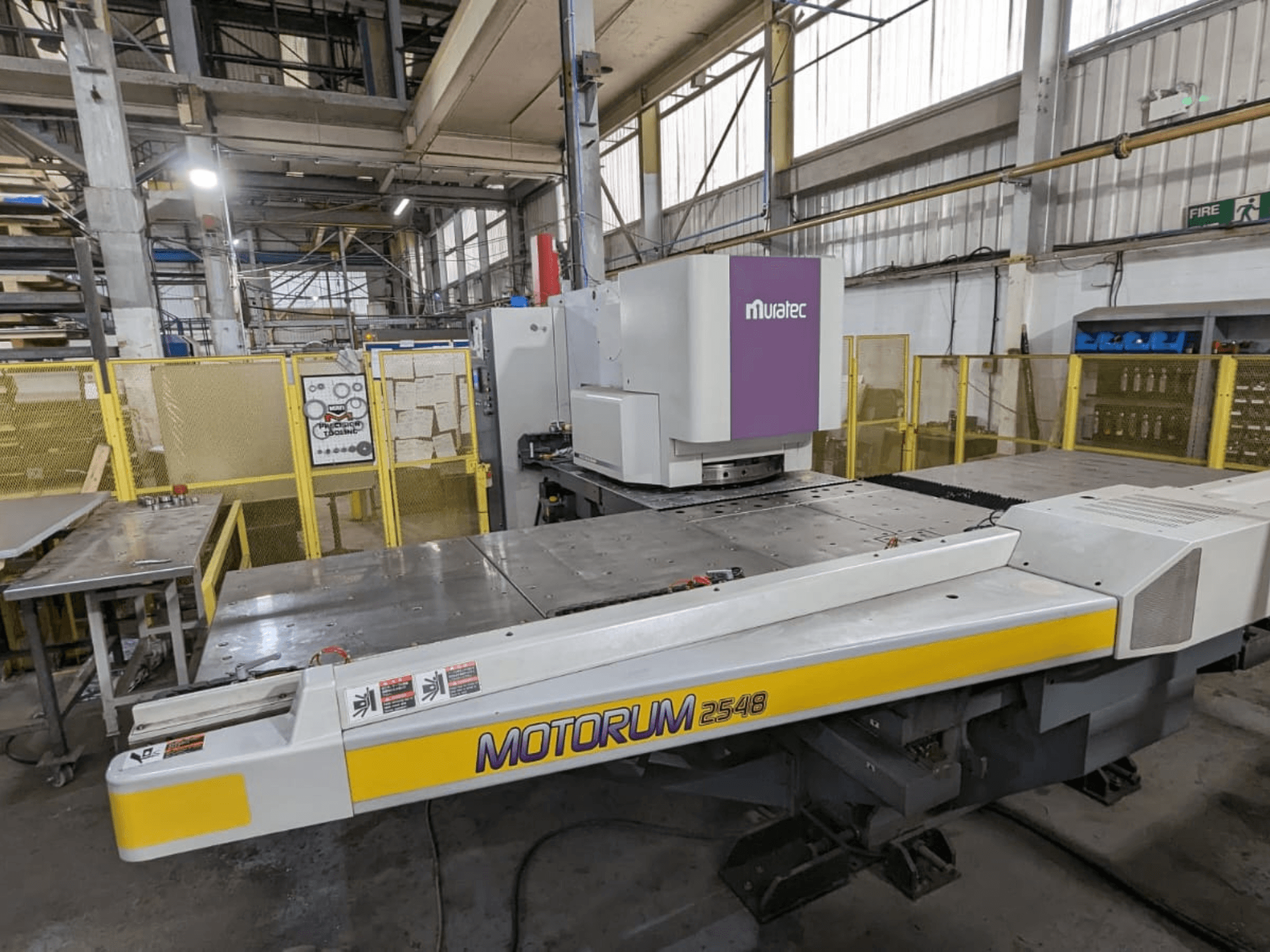 Muratec MOTORUM 2548 CNC-lävistyskone, etunäkymä, jossa näkyy ohjauspaneeli ja työpöytä tehdasasetuksissa.