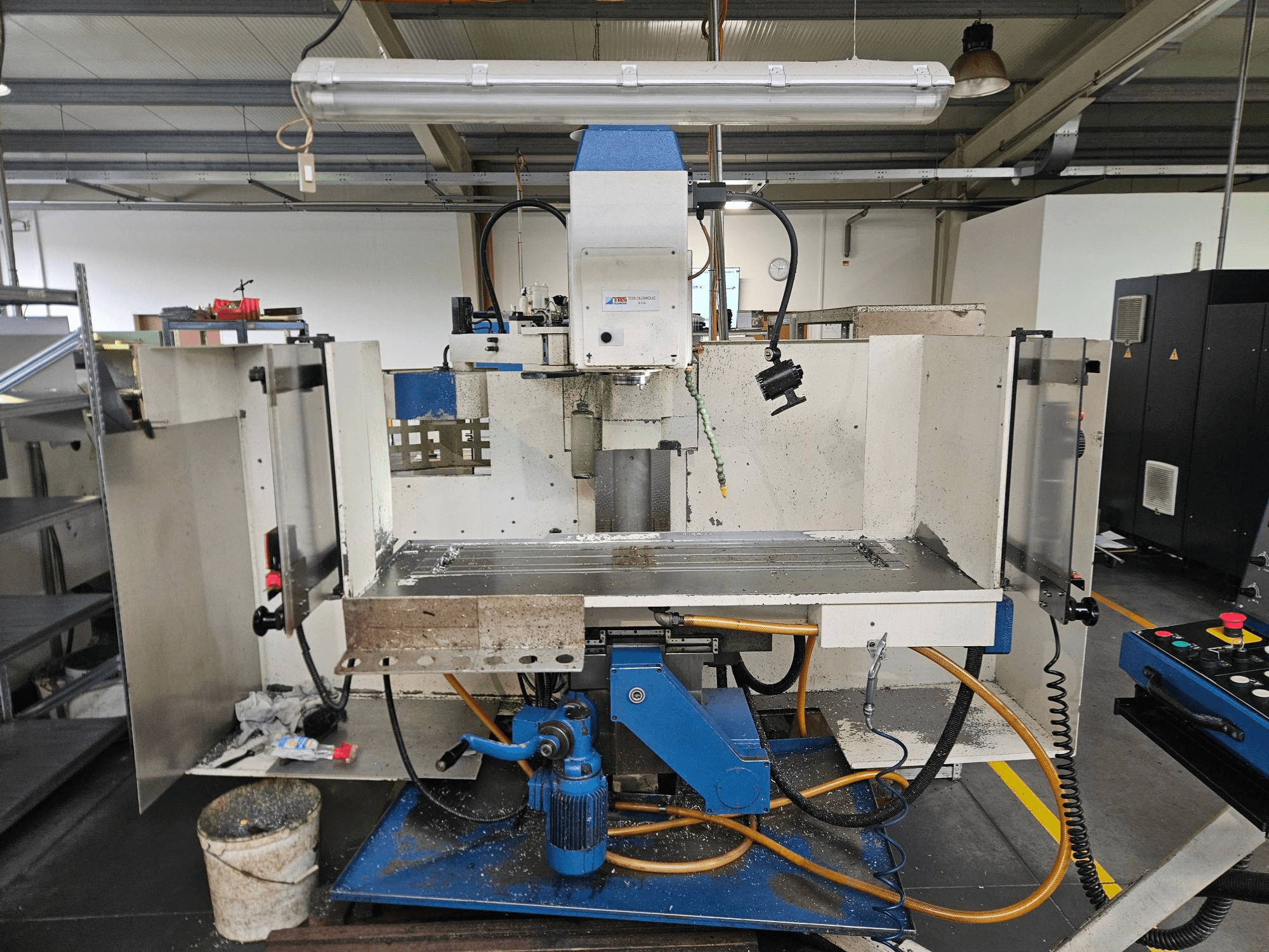 TOS Olomouc FV30 CNC Pystytyöstökeskus työpajassa, etukuva, jossa näkyy ohjauspaneeli, työpöytä ja jäähdytysjärjestelmä.