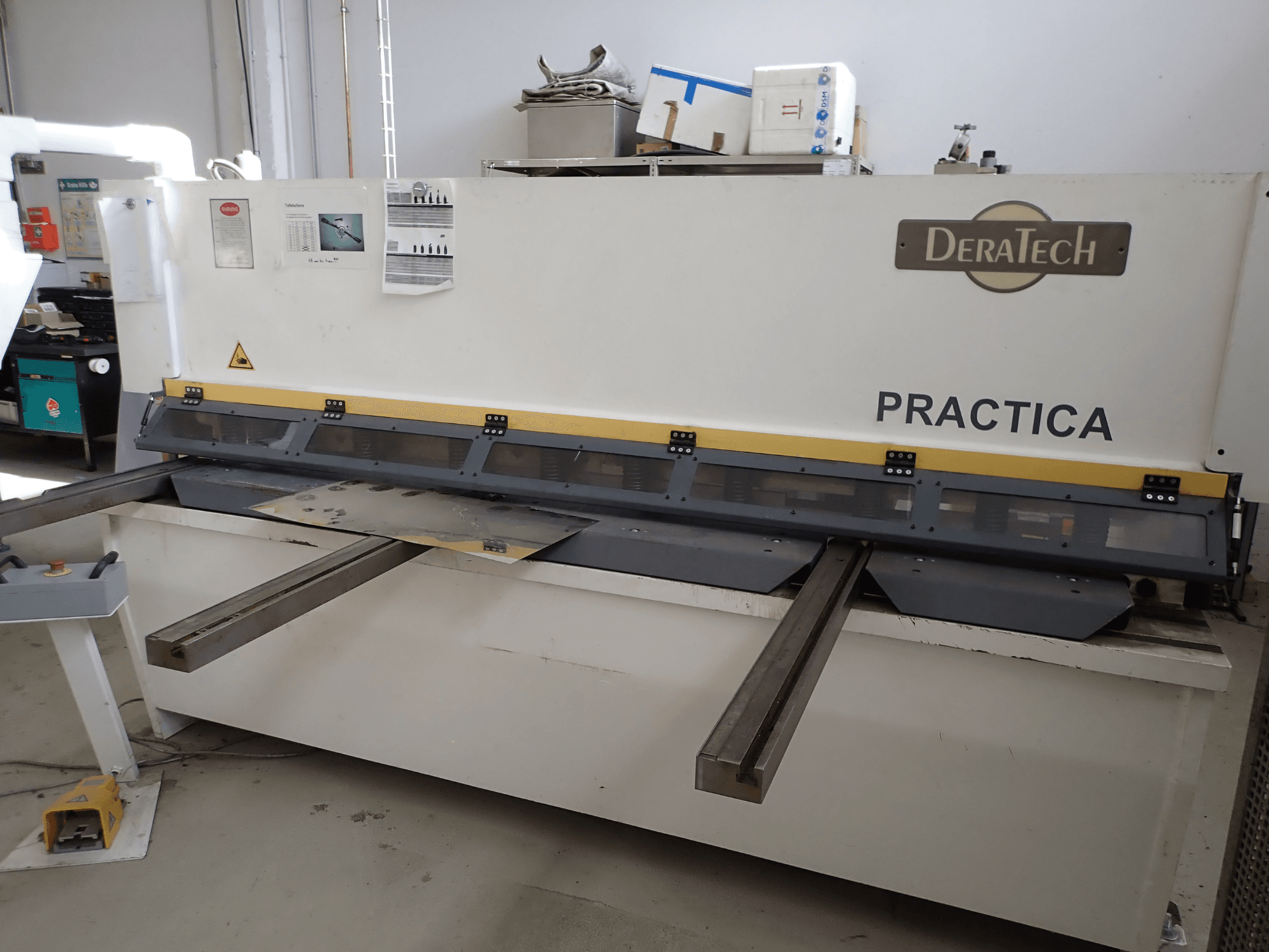 DERATECH Practica CNC-leikkuri, etukuva, jossa näkyy leikkuuterä ja metallilevyt työpinnalla.