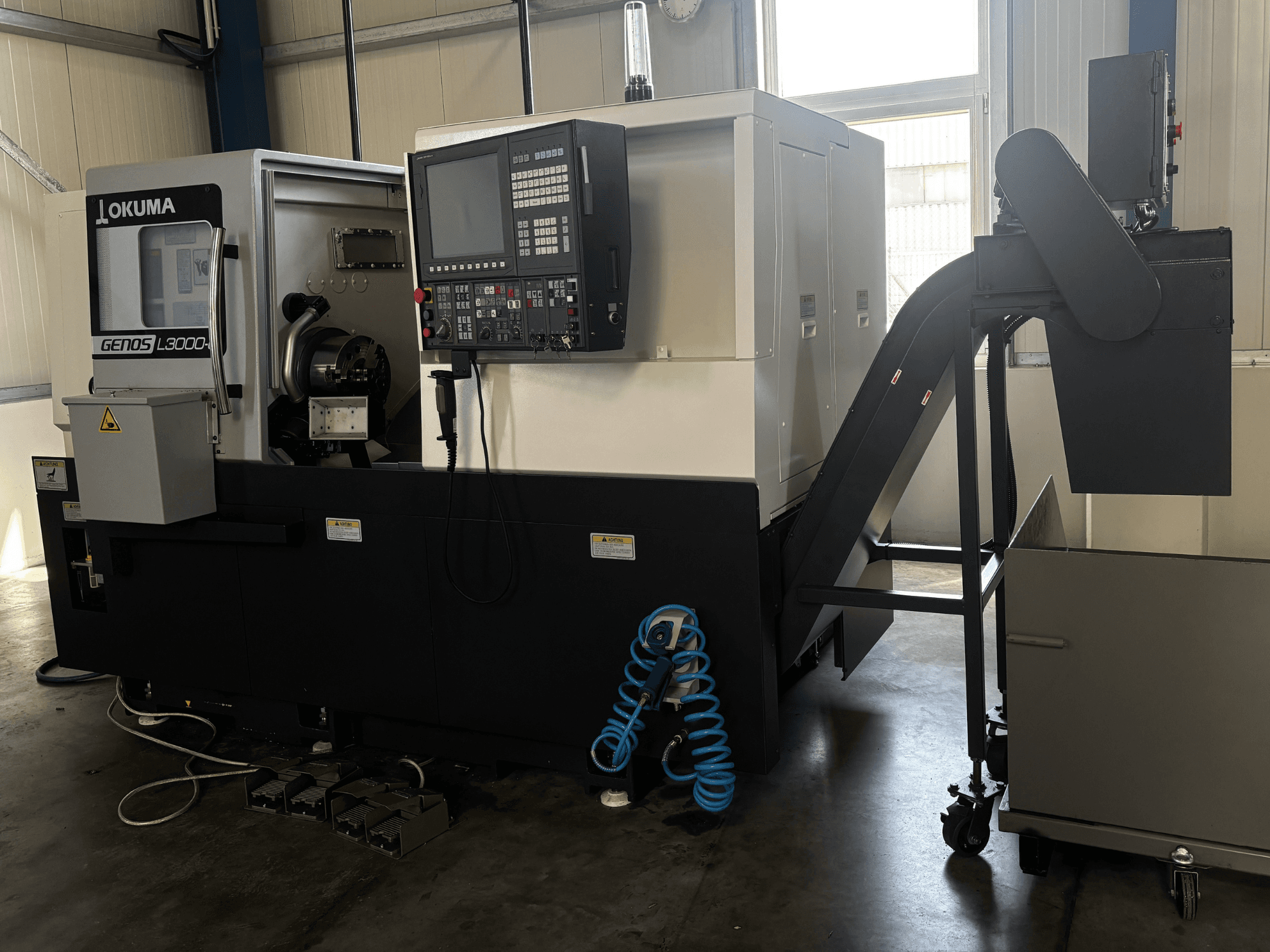 Okuma GENOS L3000-e -vaakasuora sorvi, etunäkymä, jossa näkyvät ohjauspaneeli, kuljetin ja karan alue.