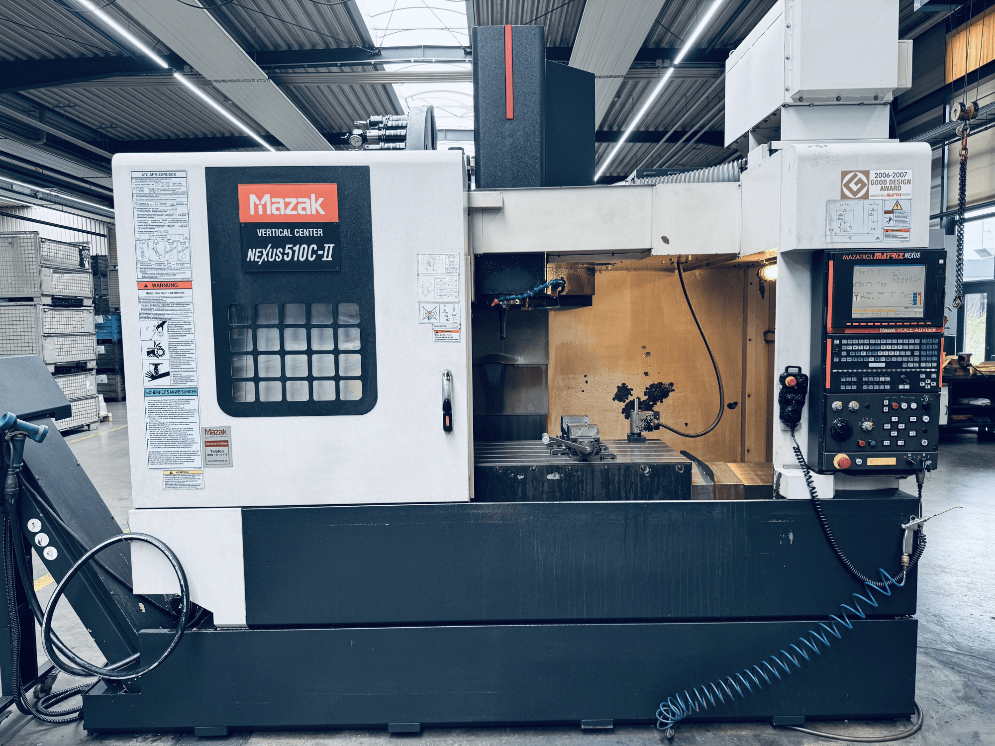 Mazak Vertical Center Nexus 510C-II, etunäkymä, jossa näkyvät ohjauspaneeli, työtila ja toiminnalliset ominaisuudet työpajaympäristössä.