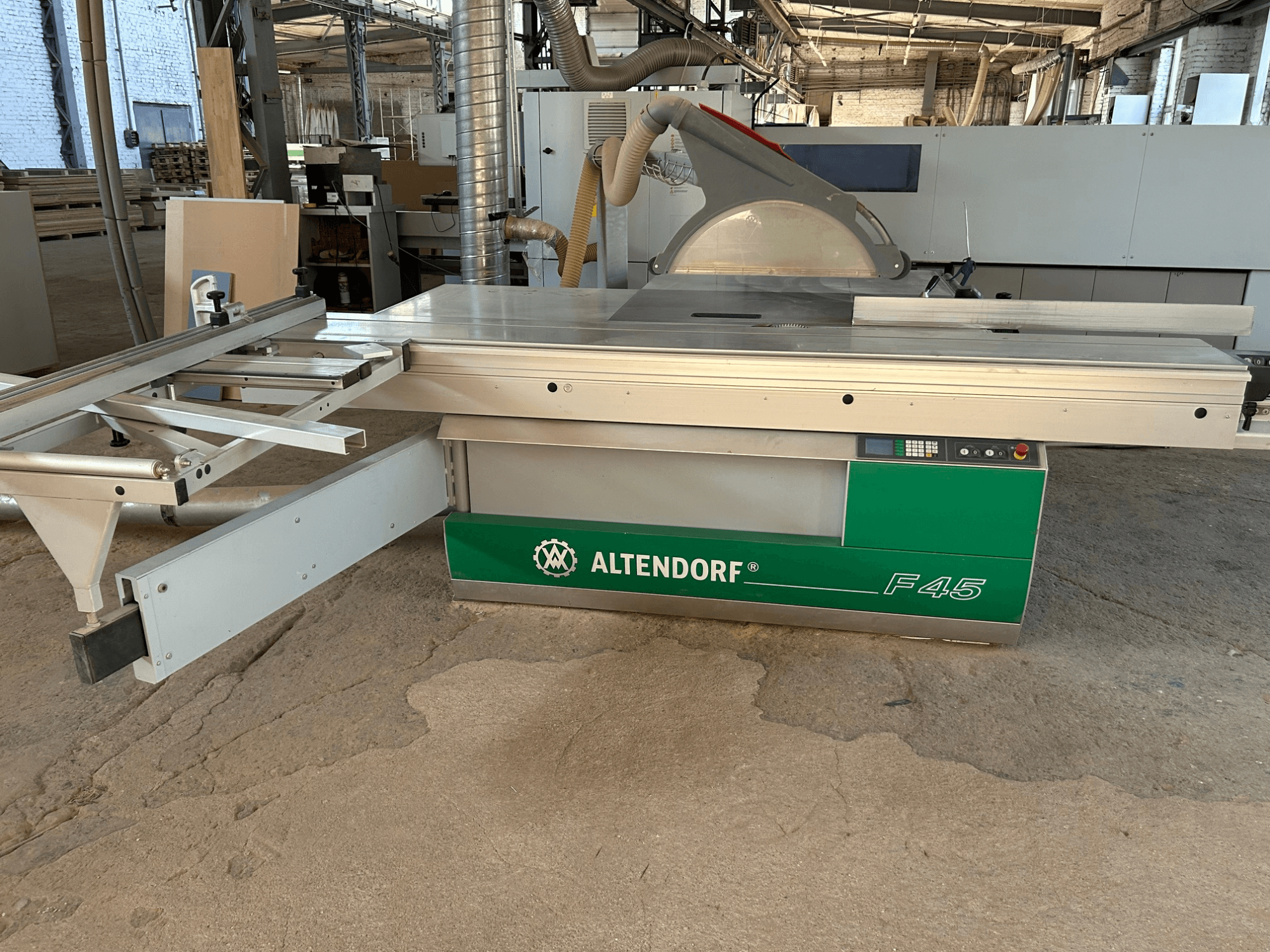 Altendorf F 45 -levysaha, etunäkymä, jossa näkyvät sahauspöytä, teränsuojus ja ohjauspaneeli vihreä-harmaassa koneessa.