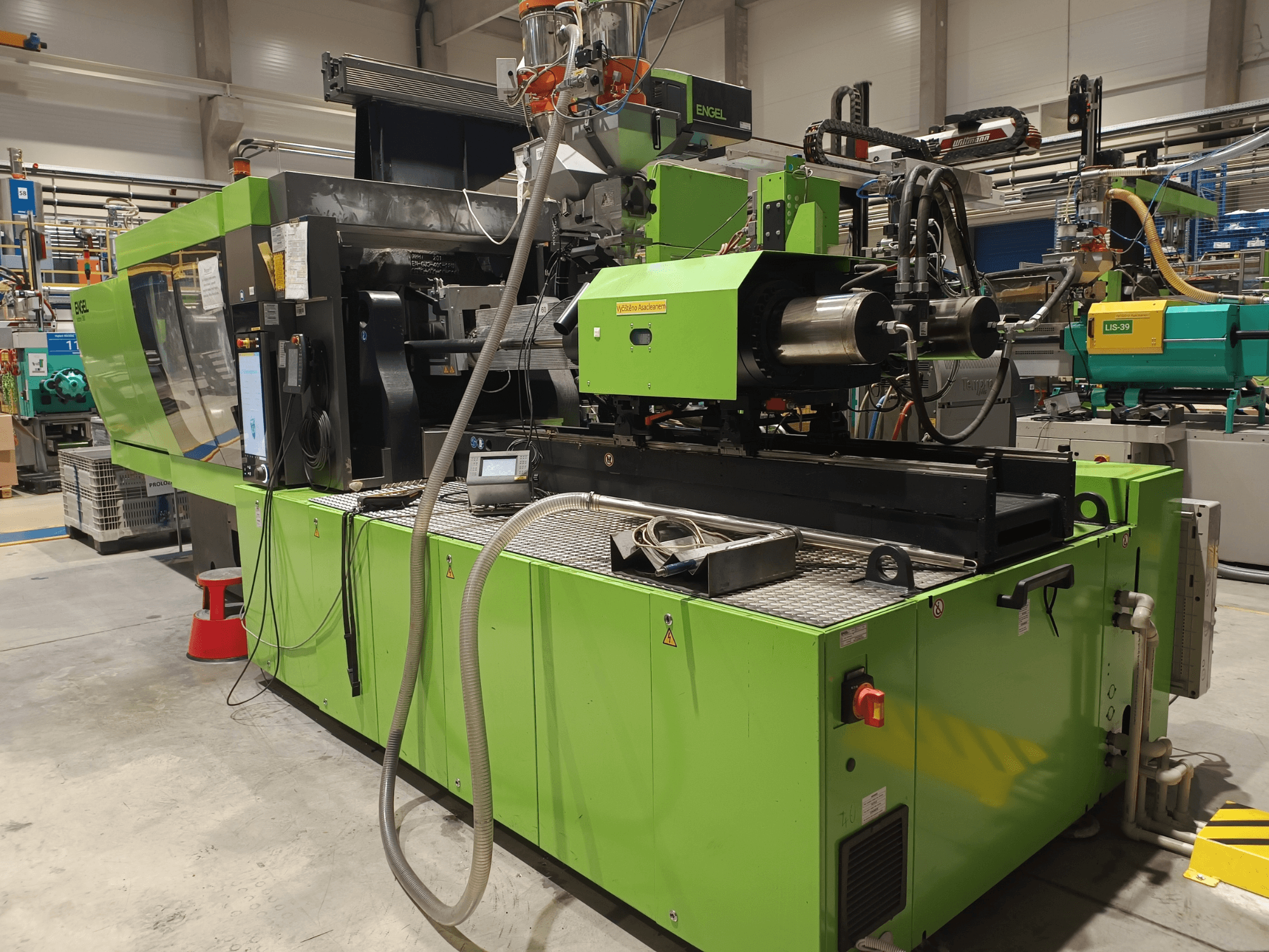 Engelin ruiskuvalukone, sivukuva, vihreä ulkopinta, kosketusnäyttöpaneeli ja hydrauliikkakomponentit näkyvissä.