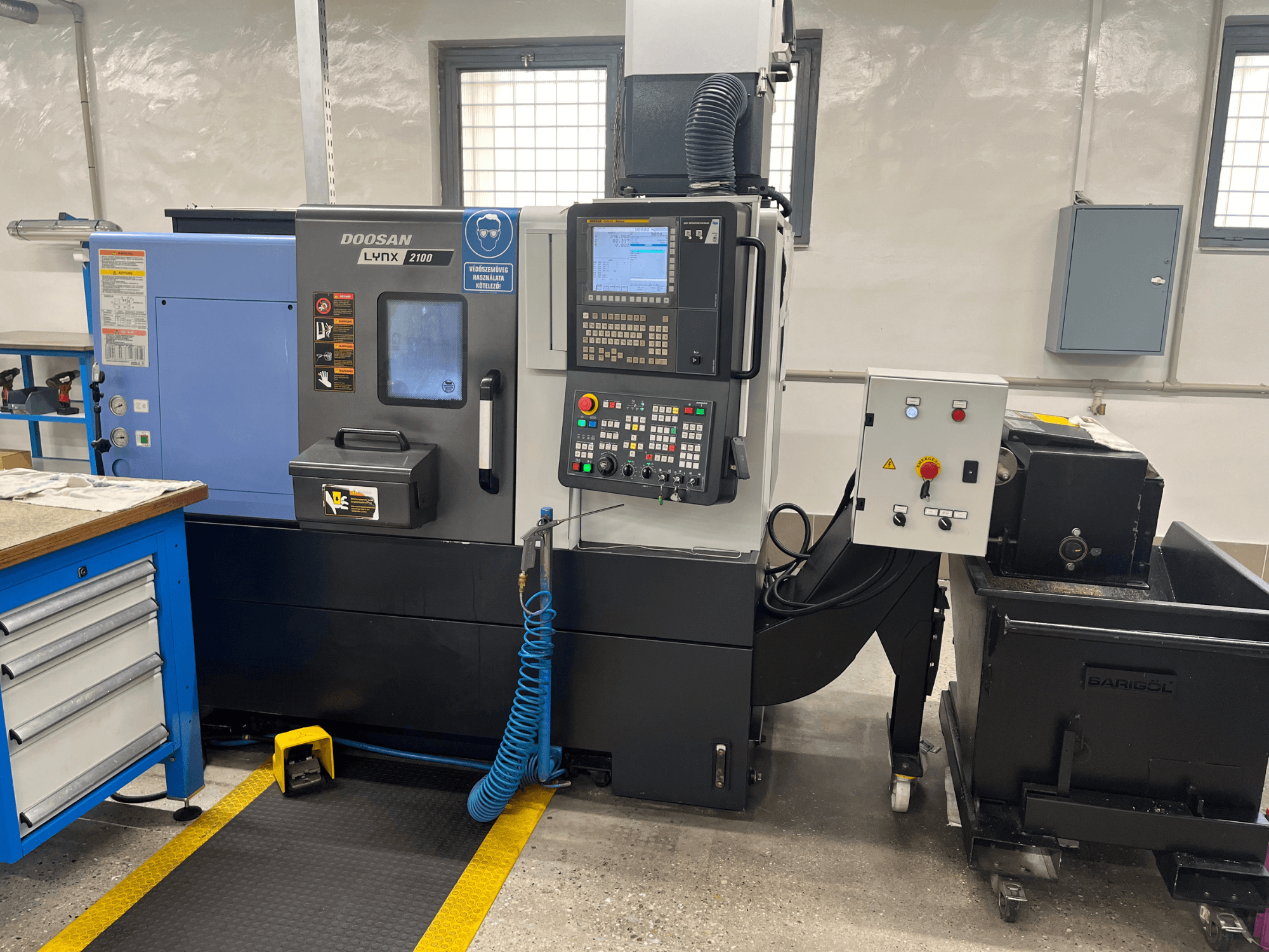 Doosan Lynx 210 -sorvi työpajassa, jossa näkyy ohjauspaneeli, työkalujen säilytys ja jäähdytysjärjestelmä, sivukuva ja työtilan yksityiskohdat.