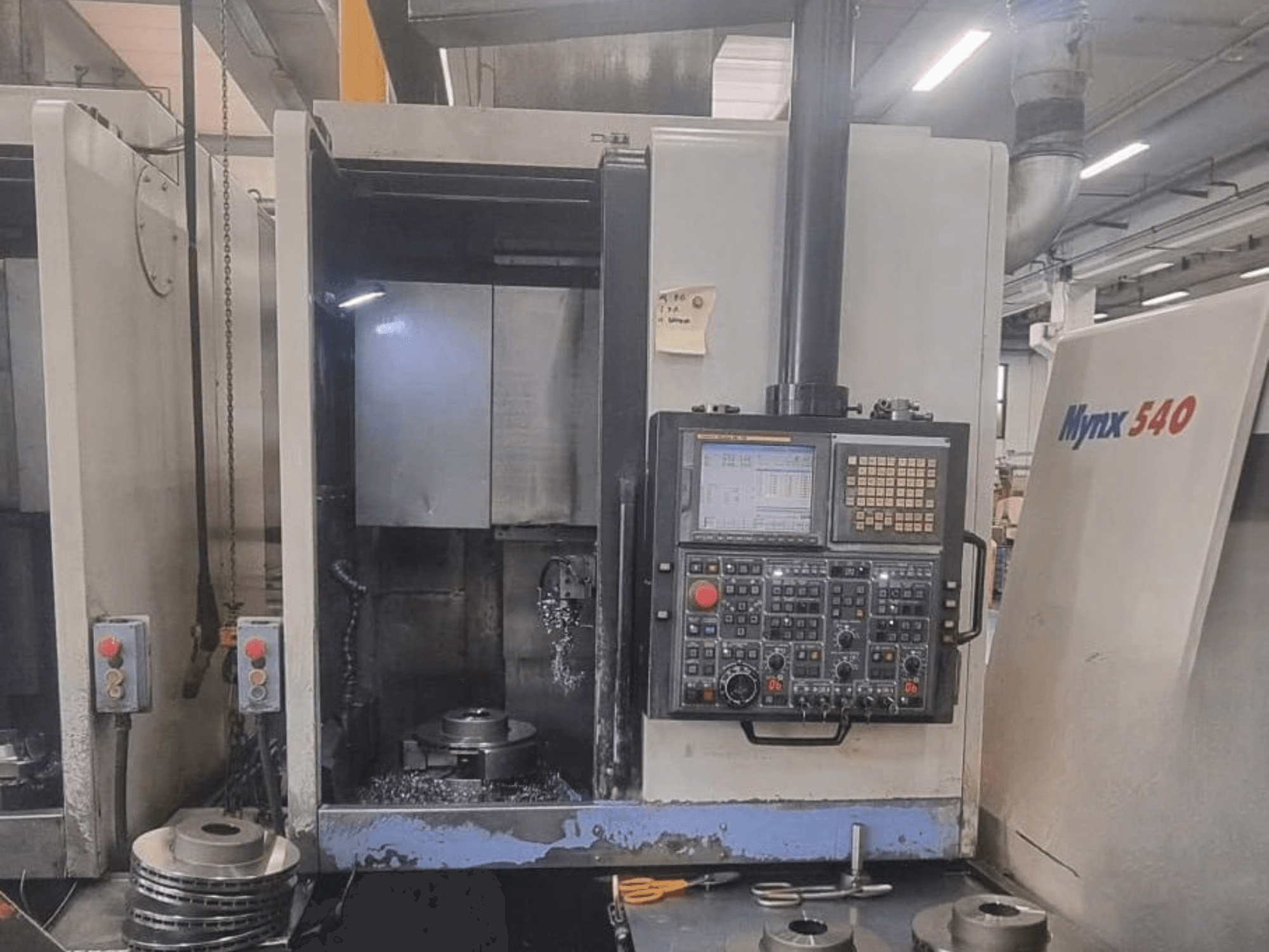 DOOSAN PUMA V400-2SP -pystysorvin etunäkymä, jossa näkyy ohjauspaneeli ja työkappaleen asennus koneen sisällä.