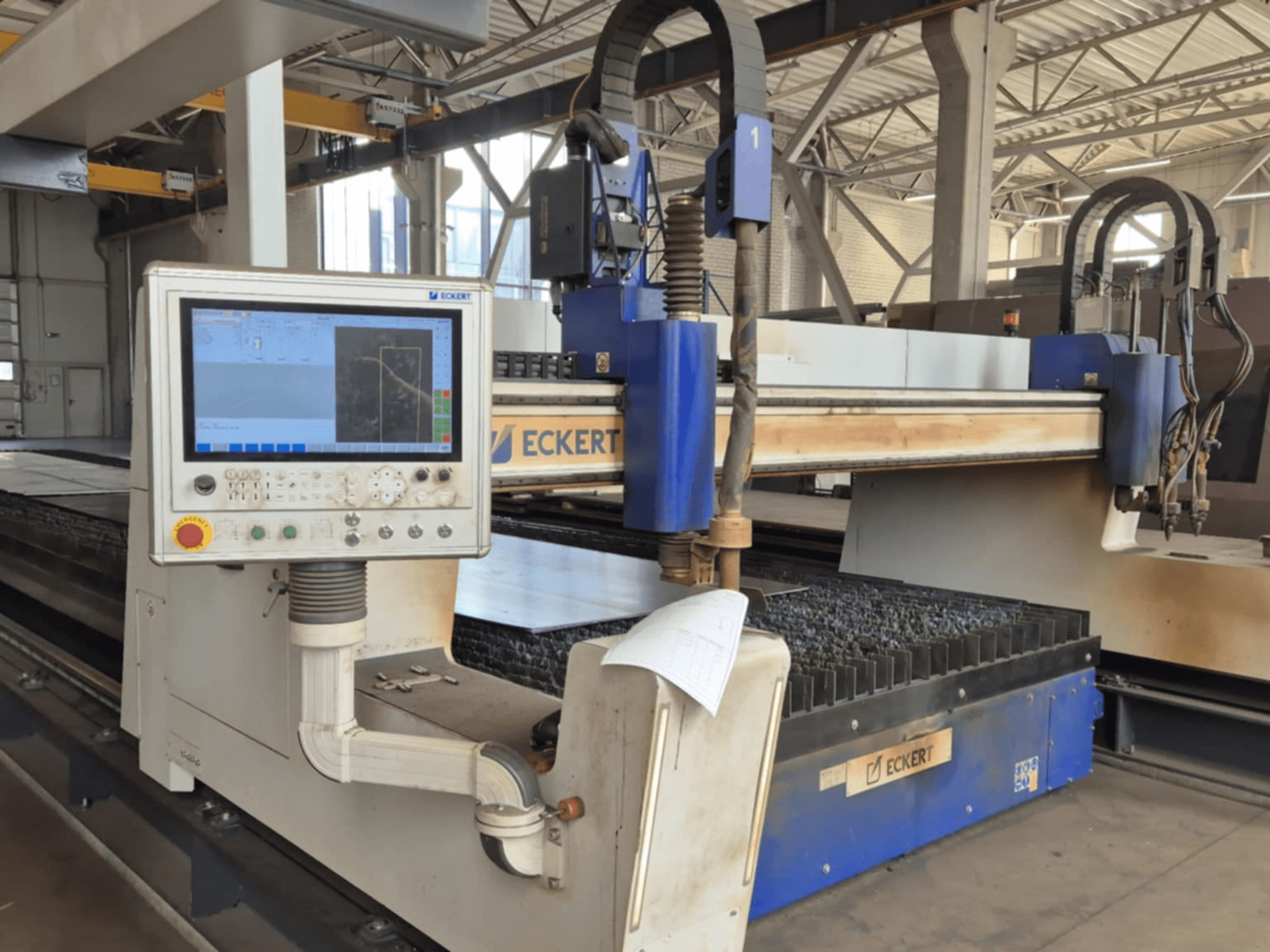 ECKERTin CNC-leikkauskoneen ohjauspaneeli etukuvassa, jossa on kosketusnäyttö ja erilaisia käyttöpainikkeita.