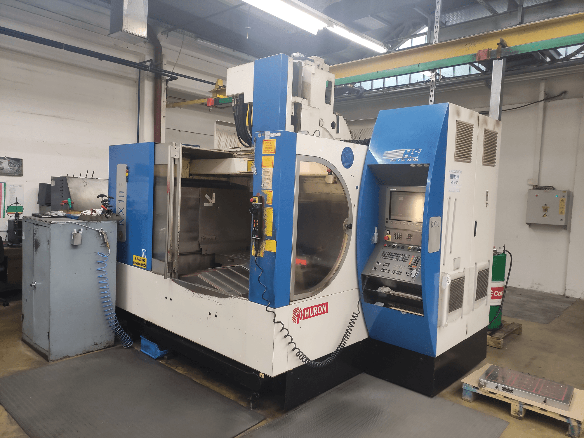 HURON KX10 CNC-kone työpajassa, etukuva, jossa on ohjauspaneeli ja suuri aukko työstöä varten.