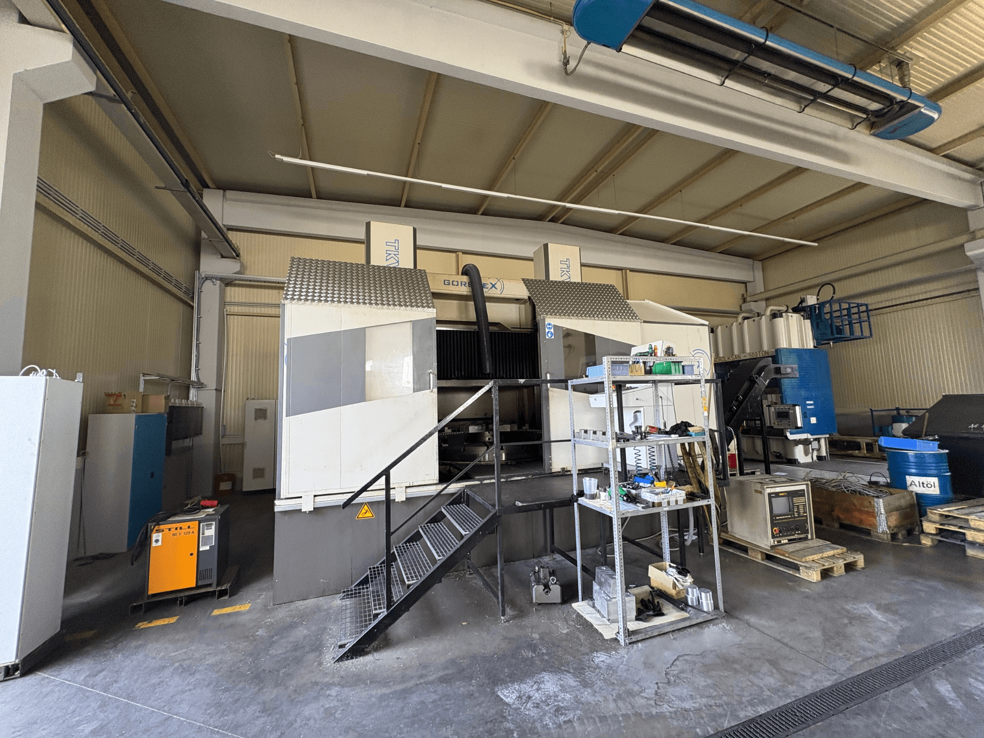 Teollinen työstöasetus GORAT X -koneella, sivukuva; sisältää työkalut, ohjauspaneelin ja laitteet hyllyillä.