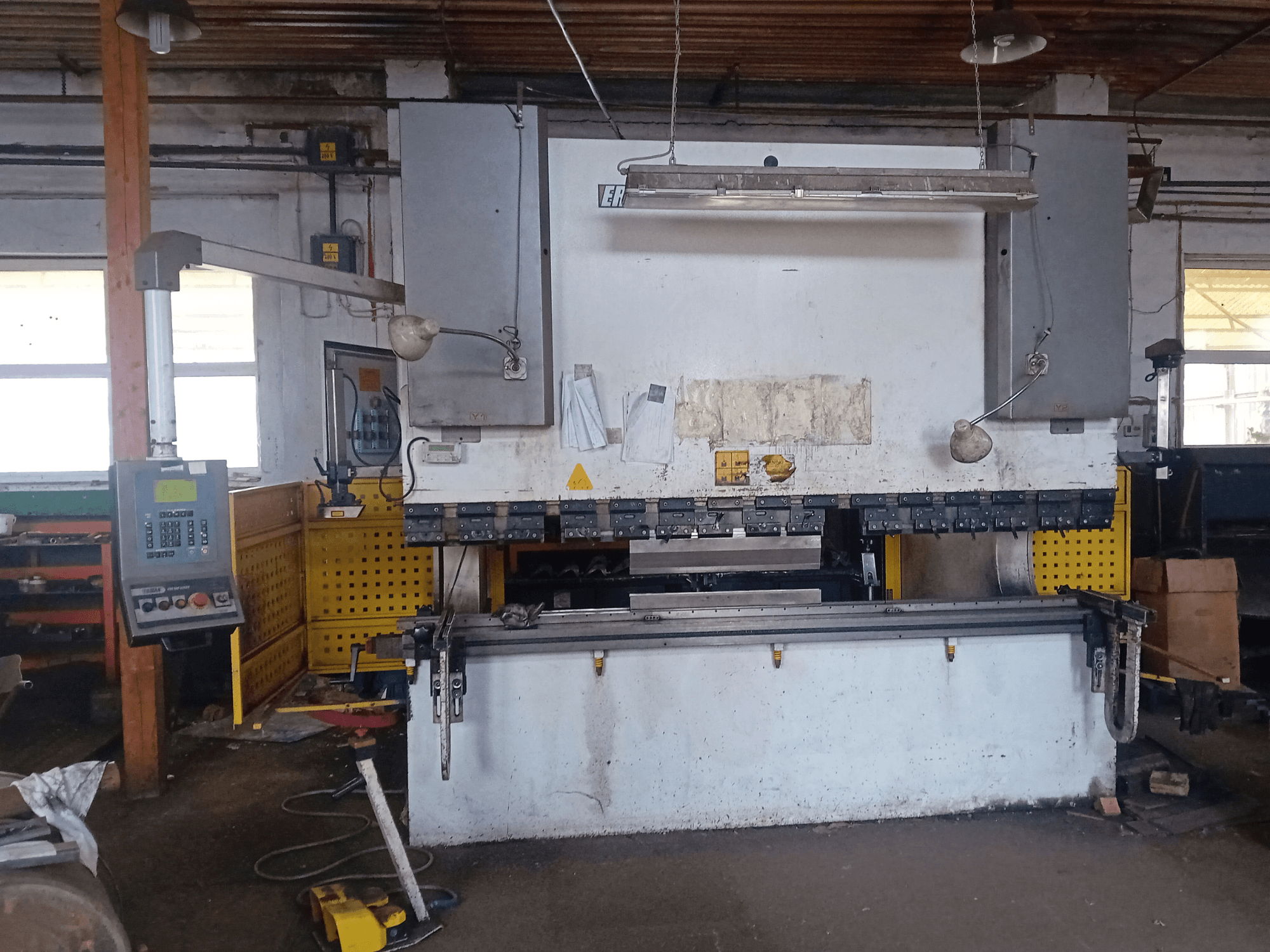ERMAK CNC HAP 3100x300 hydraulinen puristin edestäpäin, jossa on ohjauspaneeli ja työpöytä työpajassa.