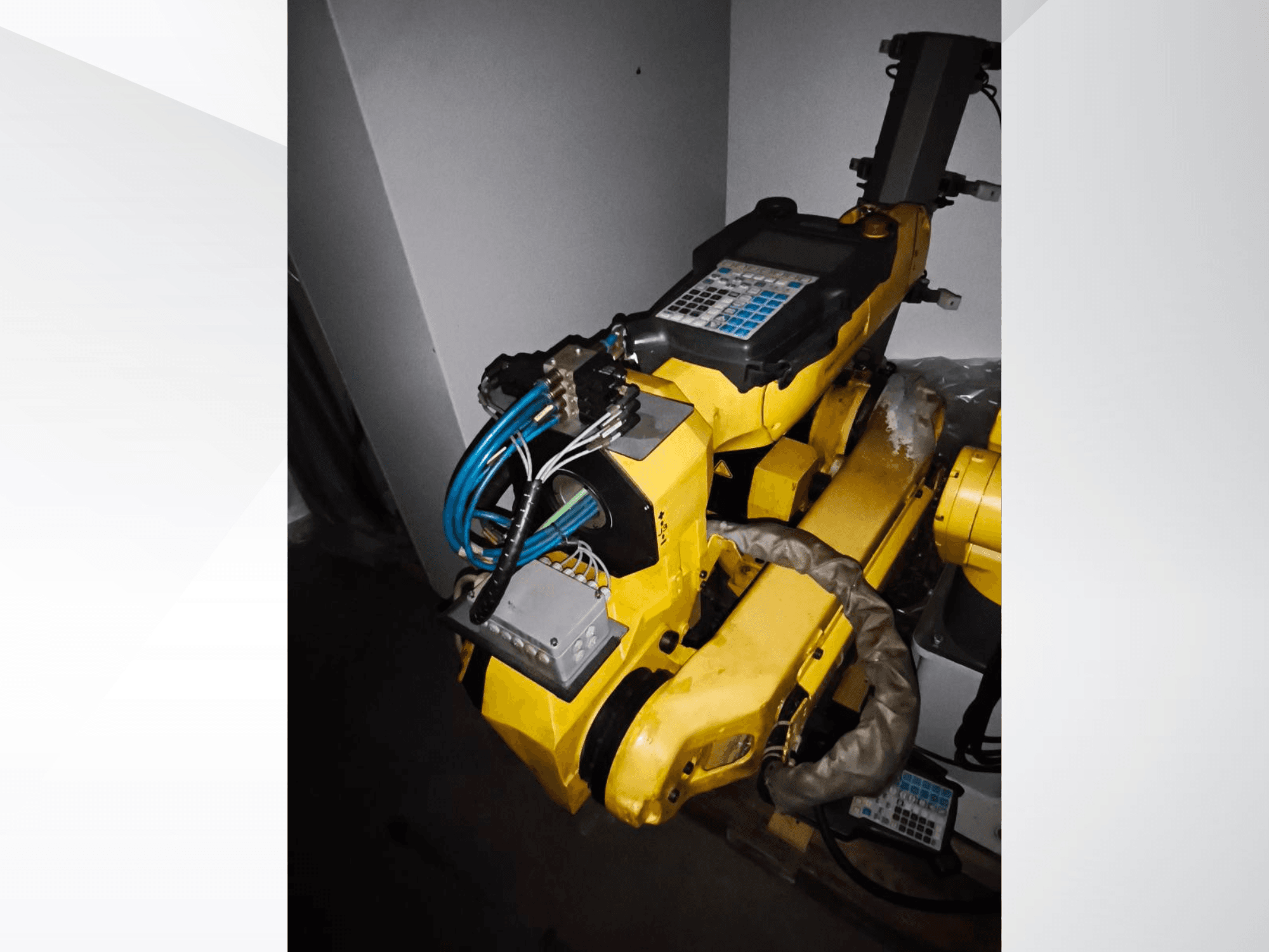 FANUC M-20iA -robottivarsi sivukuvassa, jossa näkyy keltainen runko, ohjauspaneeli ja liitetyt johdot.