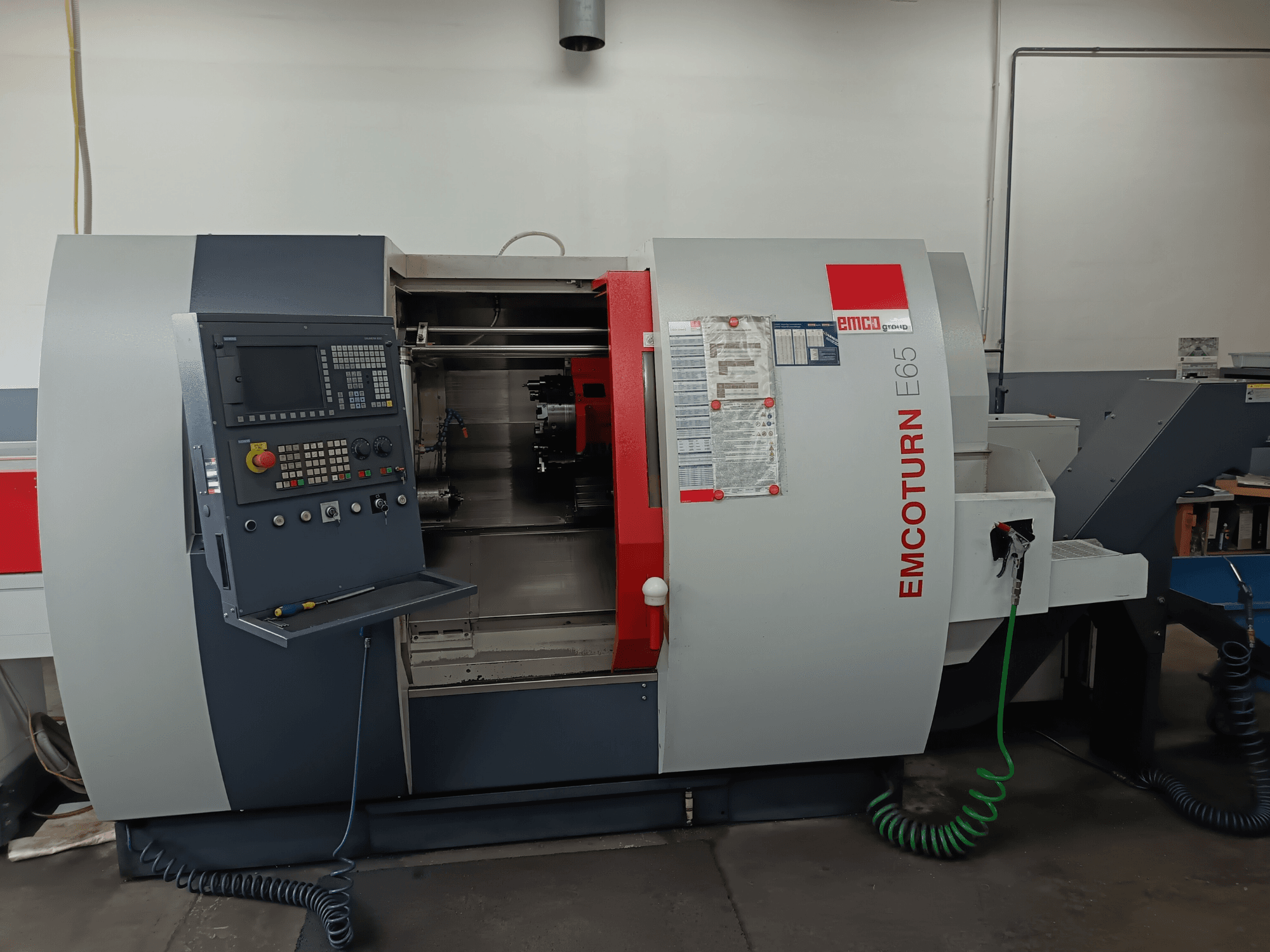 EMCO EMCOTURN E65 -kääntökeskus, etukuva, jossa näkyy ohjauspaneeli, sisäinen mekanismi ja ominaisuudet työpajassa.
