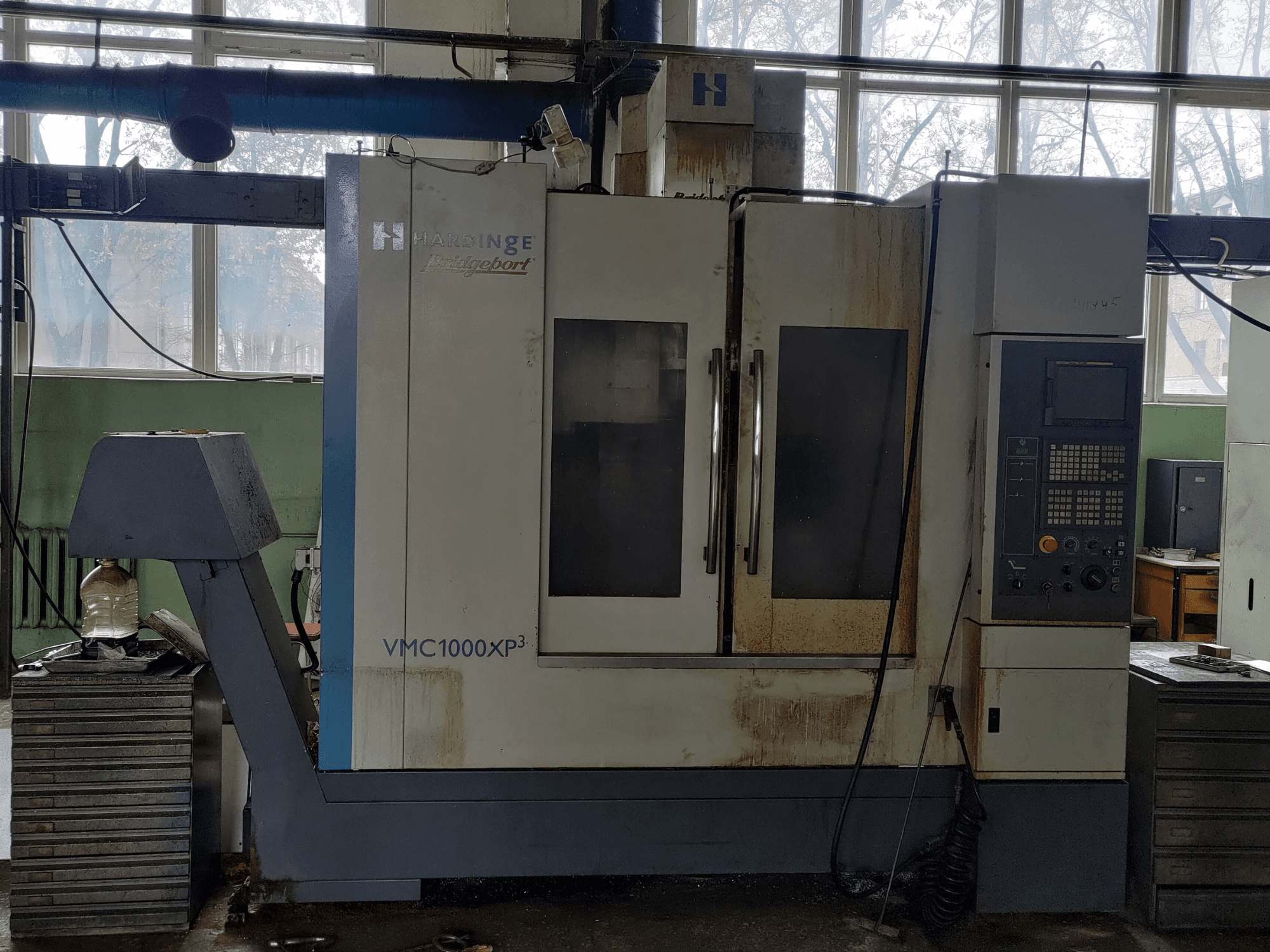 Bridgeport VMC1000 XP3 -pystykoneistuskeskus edestä katsottuna; kuvassa näkyy ohjauspaneeli ja vähäistä kulumista.