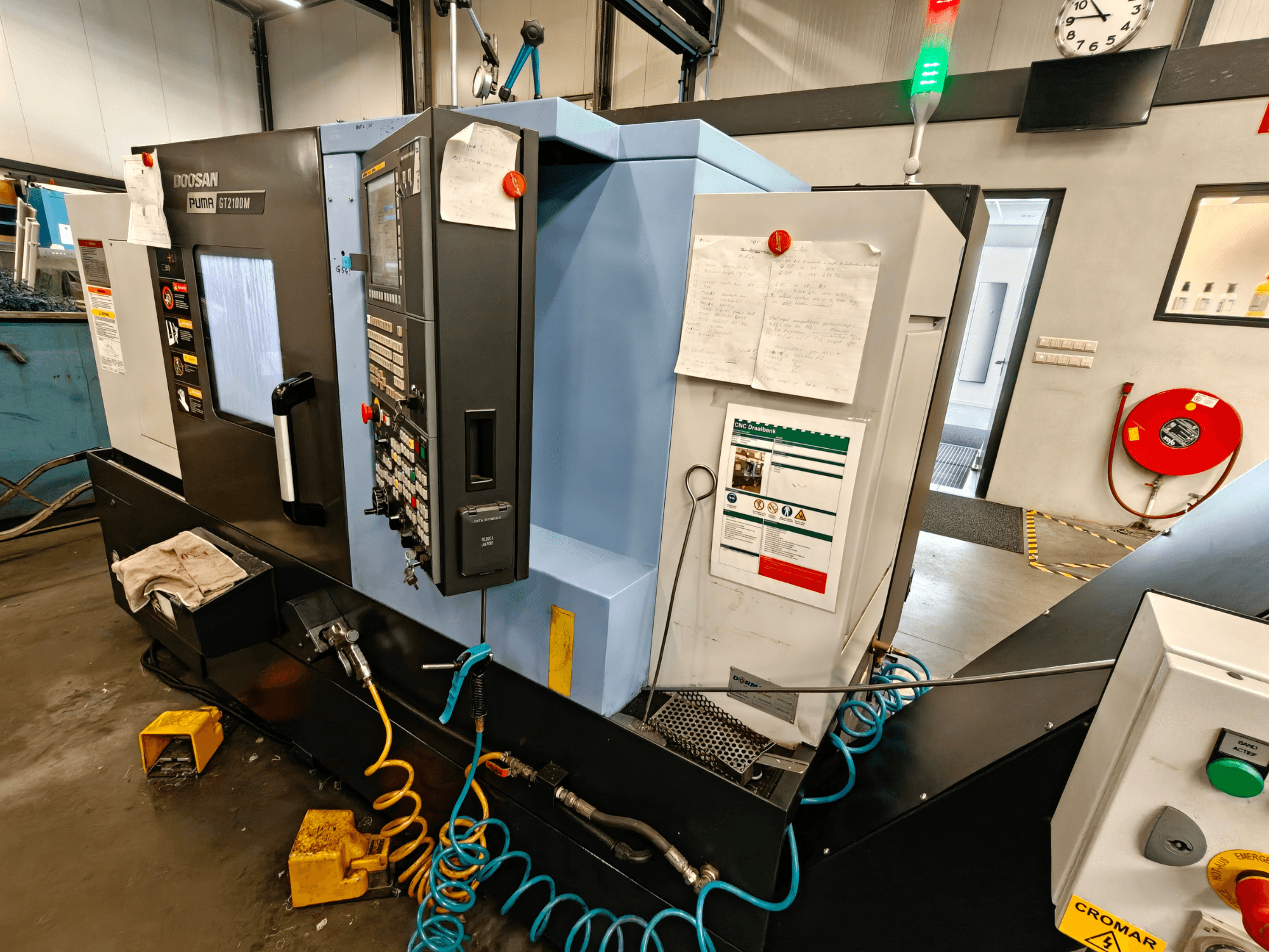 DOOSAN Puma GT 2100M -vaakasorvauskoneen etukuva, jossa ohjauspaneeli, turvaominaisuudet ja huoltomerkinnät näkyvissä.