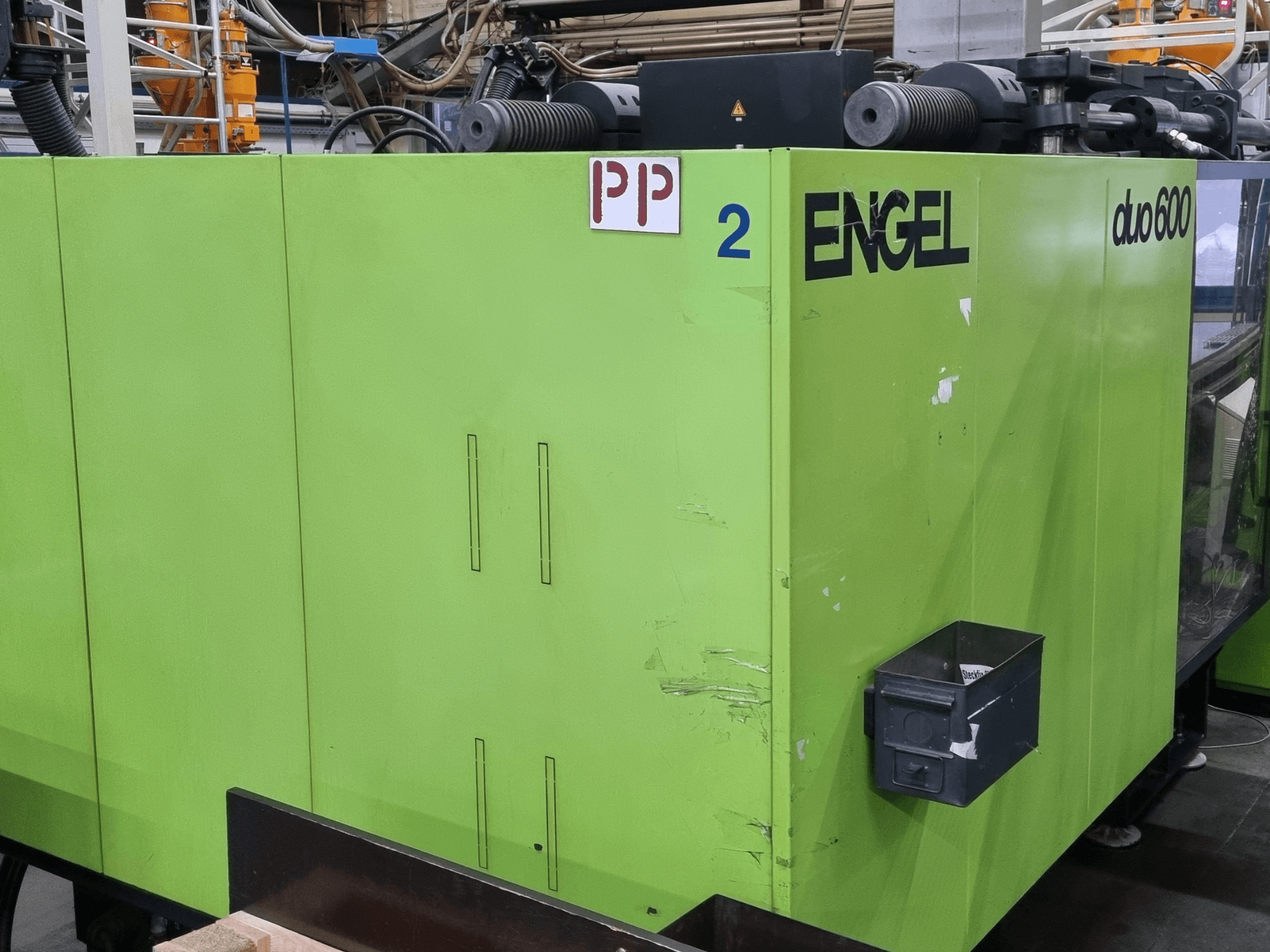 Engel Duo 600 -hydraulinen ruiskuvalukone, vihreä ulkopinta, etunäkymä, merkityt osat ja materiaalin säilytyslaatikko.
