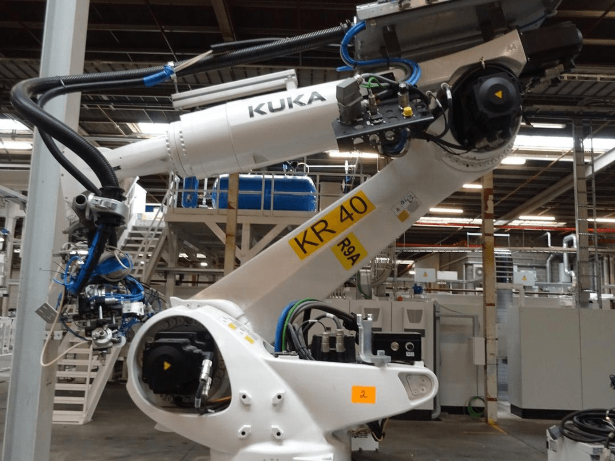 KUKA KR 120 R3100-2 -robottivarsi sivukuvassa, jossa on ohjauspaneeli ja mekaaniset komponentit teollisuusympäristössä.