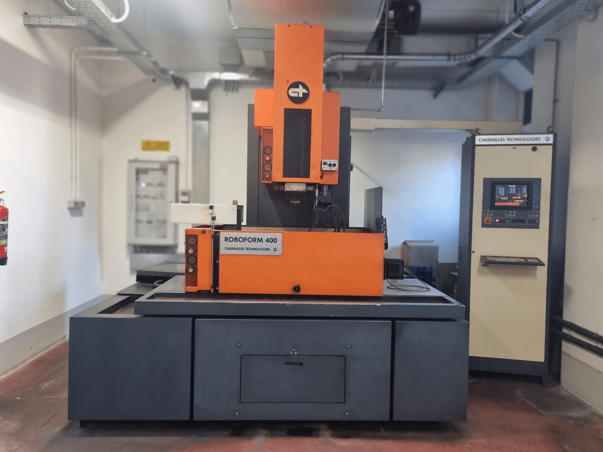 Charmilles Technologiesin Roboforn 400 -kone, etukuva, oranssi ja harmaa muotoilu, digitaalinen ohjauspaneeli näkyvissä.