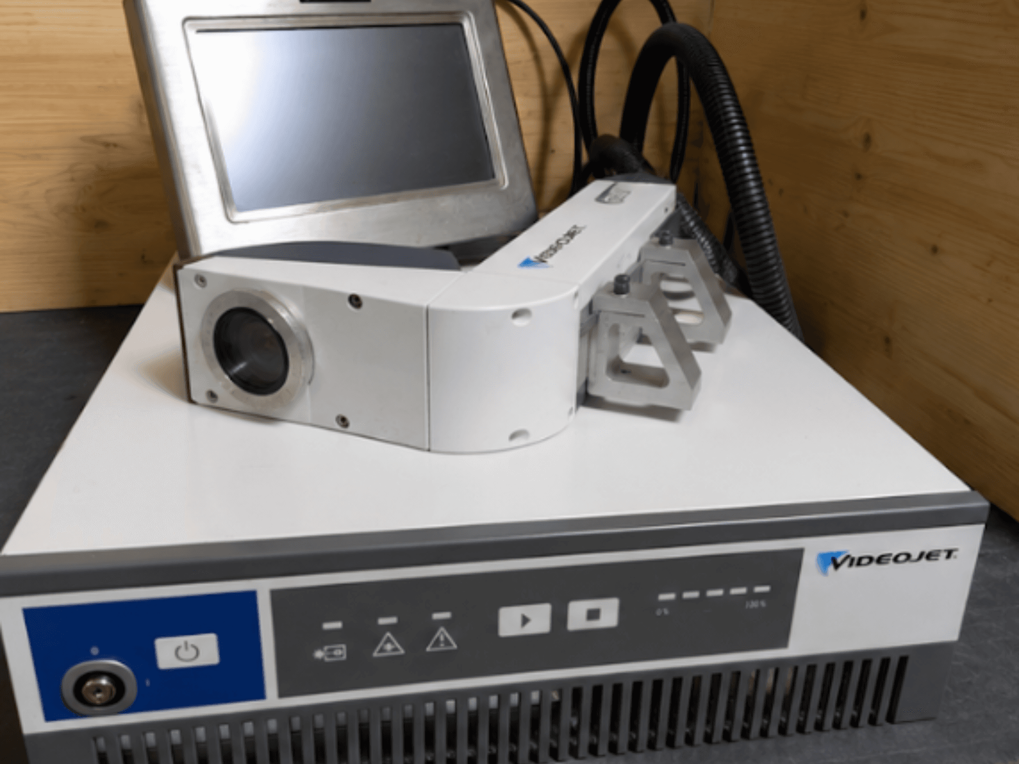 Videojet 7230 -laserkaiverruskone, etukuva, jossa näkyy ohjauspaneeli ja laserpää linssin ja kiinnityksen kanssa.