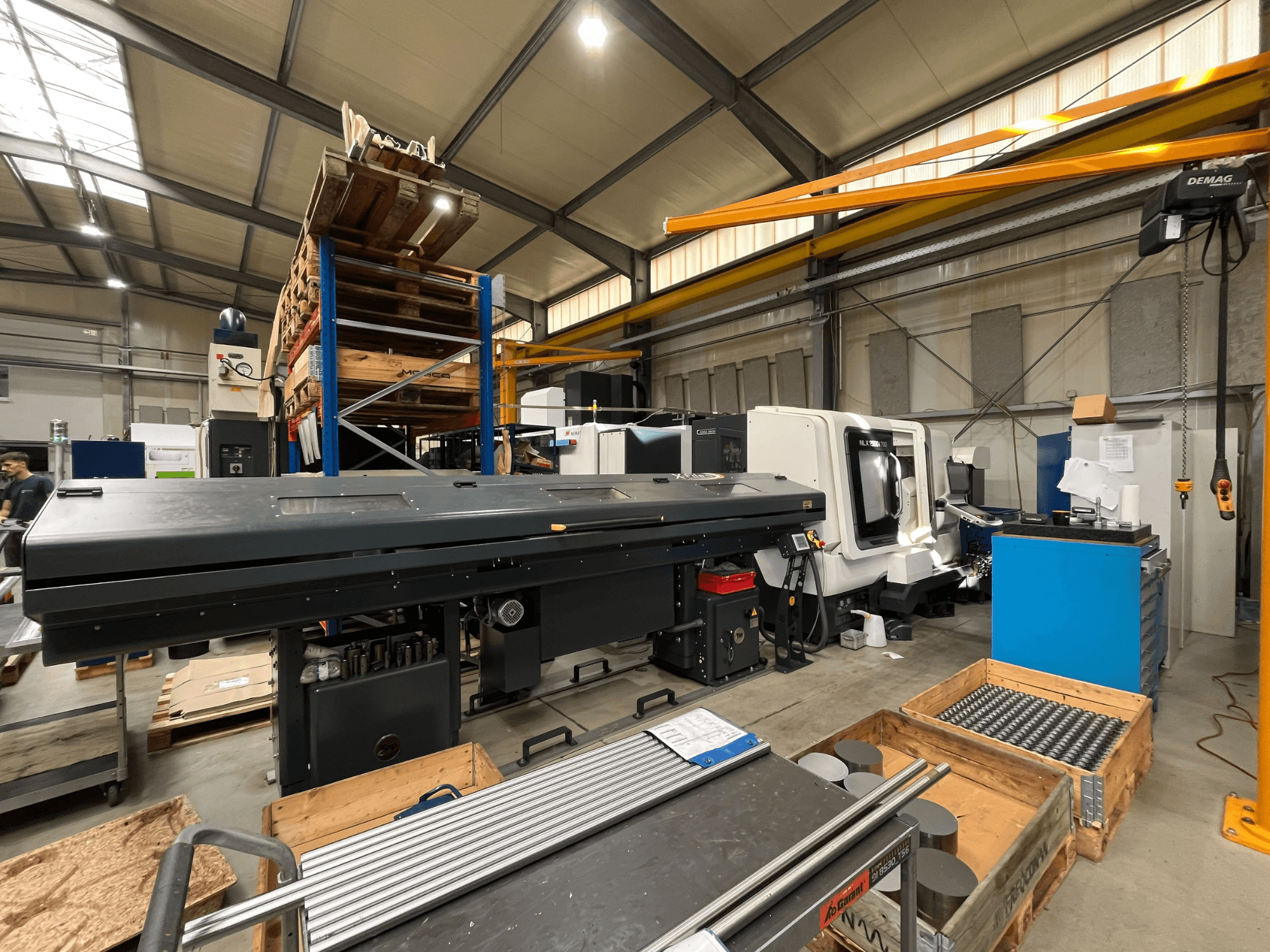 DMG MORI MORI NLX 2500/700 SY -vaakasuora sorvi työpajassa, sivulta katsottuna, taustalla varastotila ja työkalut.