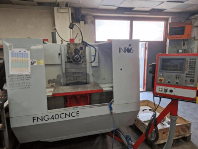 INTOS FNG40CNC -kone, etukuva, jossa on ohjauspaneeli, käyttöosat ja metallinen työpöytä. Ihanteellinen koneistukseen.