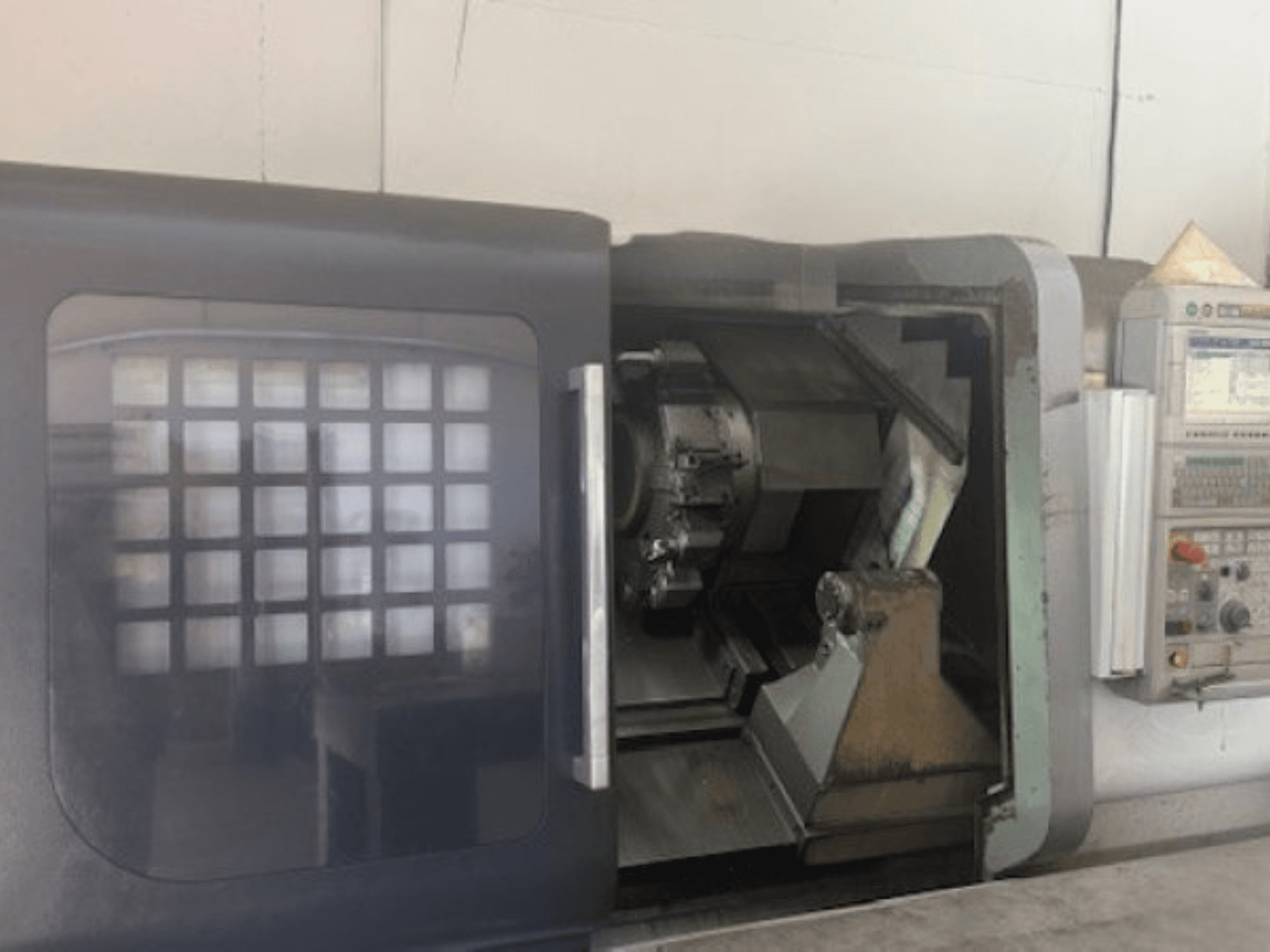 MORI SEIKI NLX 2500M vaakasuuntainen sorvauskone, etukuva, jossa näkyy työkalunpidin, ohjauspaneeli ja sisäinen mekanismi.