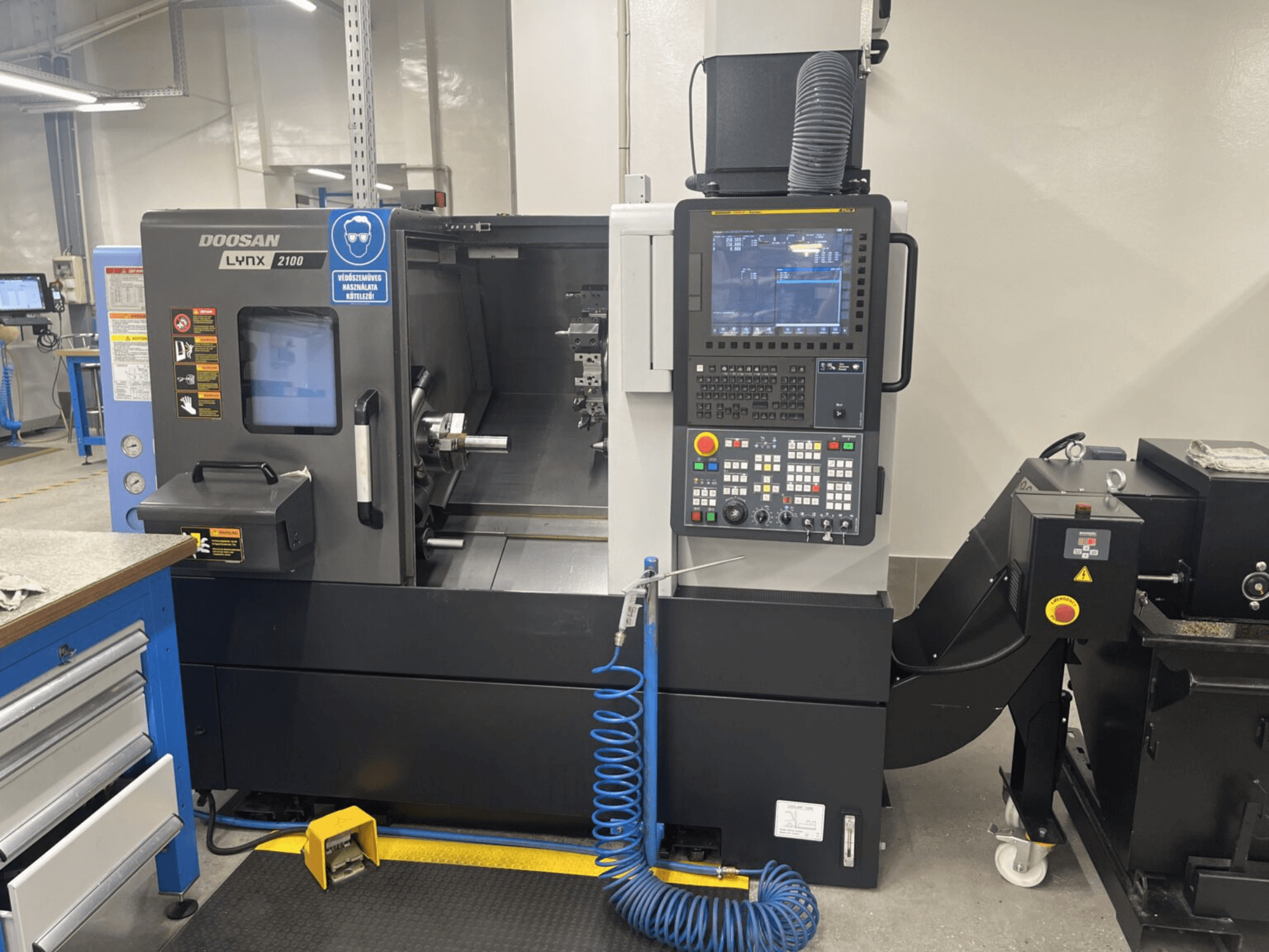 DOOSAN Lynx 2100A -vaakasorvauskoneen etukuva, jossa näkyy ohjauspaneeli ja karan alue sekä huomattavat turvaominaisuudet.