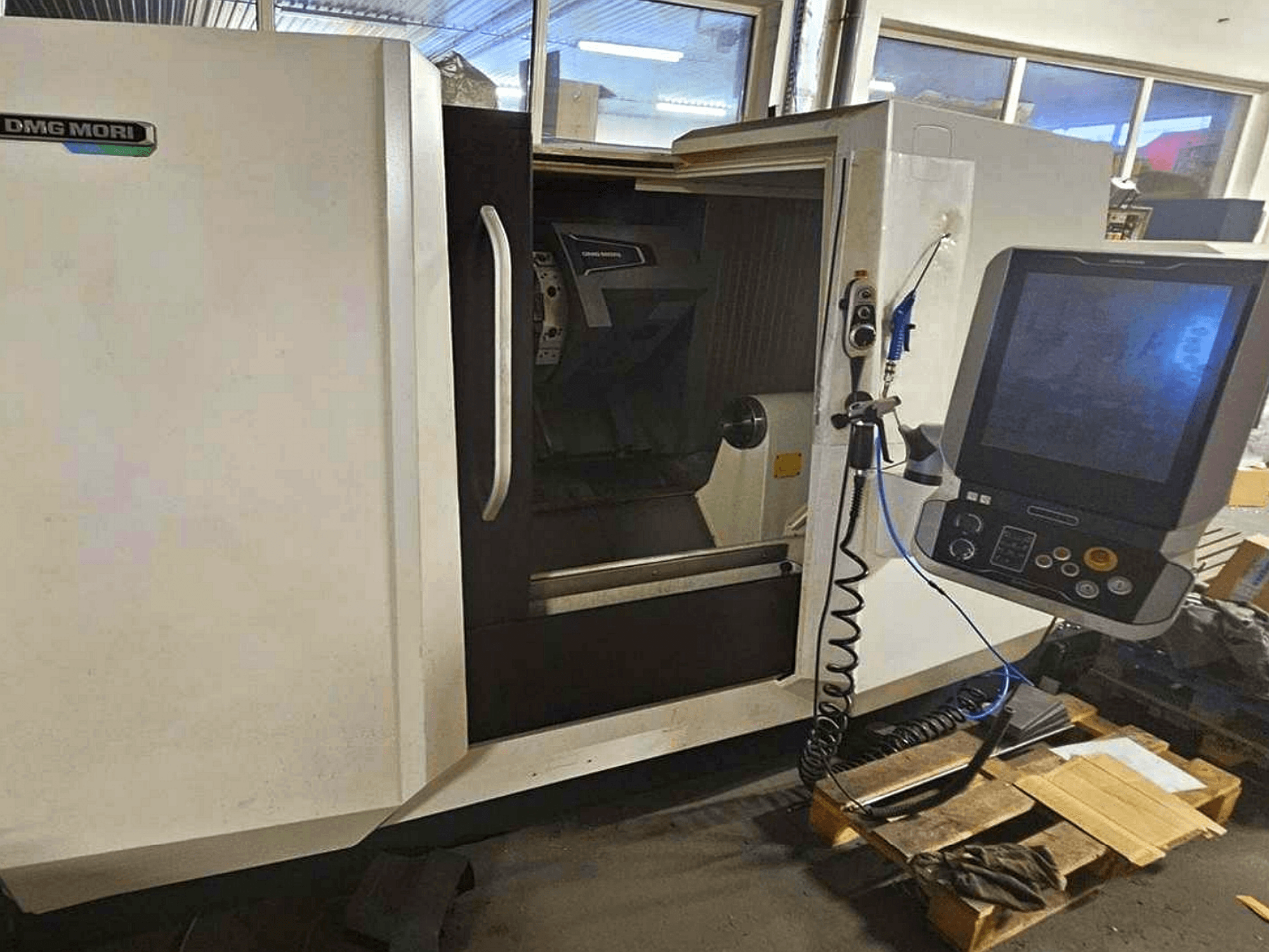 DMG MORI CLX 450 V4 vaakasuuntainen sorvauskone, etukuva ohjauspaneelista, jossa näkyy työtila ja rungon muotoilu.