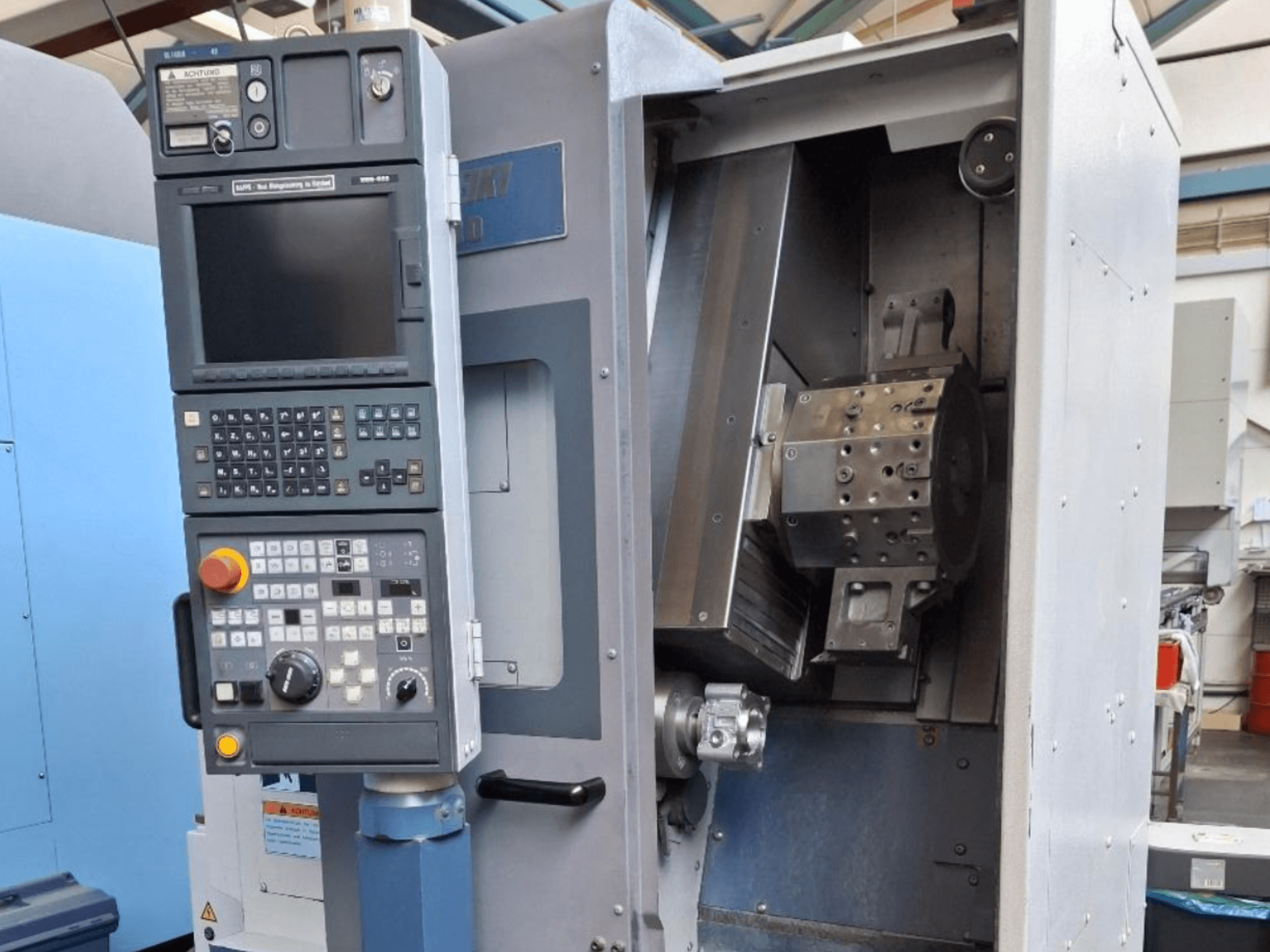 MORI SEIKI SL 1000 vaakasuuntainen sorvauskone etukuvassa, jossa on ohjauspaneeli ja yksityiskohtainen sisäinen mekanismi.