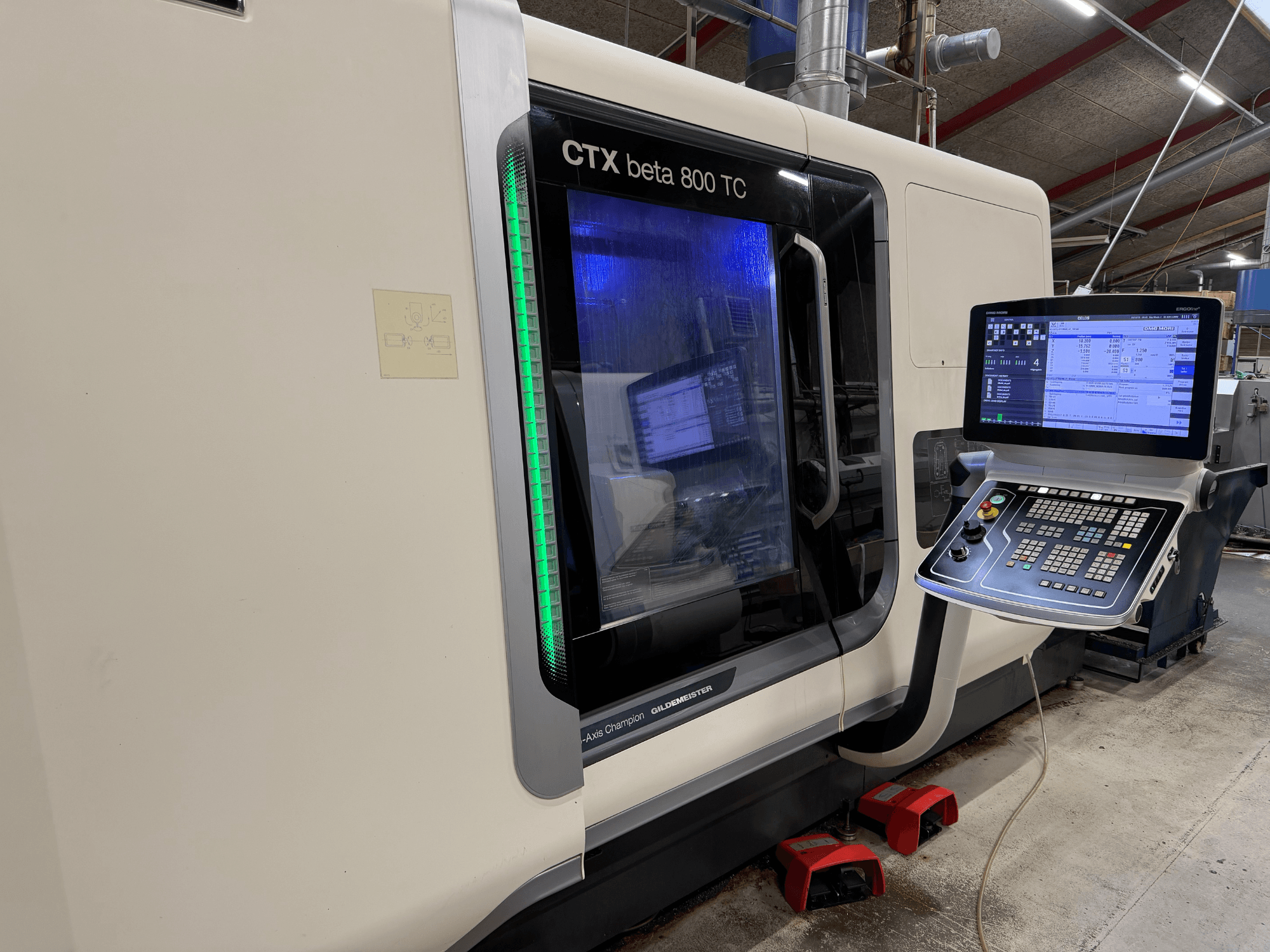 CTX beta 800 TC CNC-kone sivukuvassa, jossa on digitaalinen ohjauspaneeli ja valaistu vihreä turvamerkkivalo.