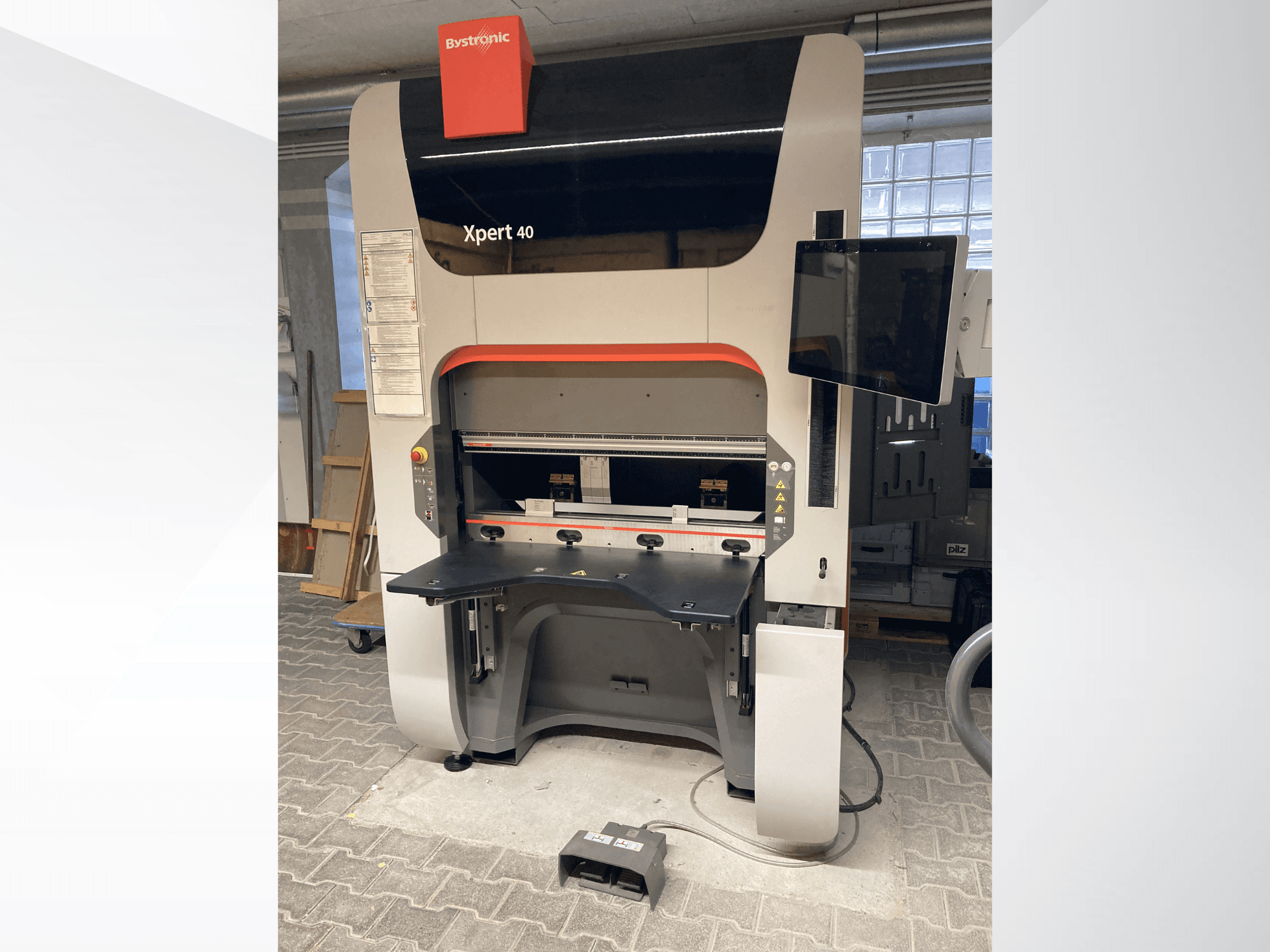 Bystronic Xpert 40/1030 -puristimen etukuva, jossa näkyy ohjauspaneeli, työtaso ja liitetty näyttö.