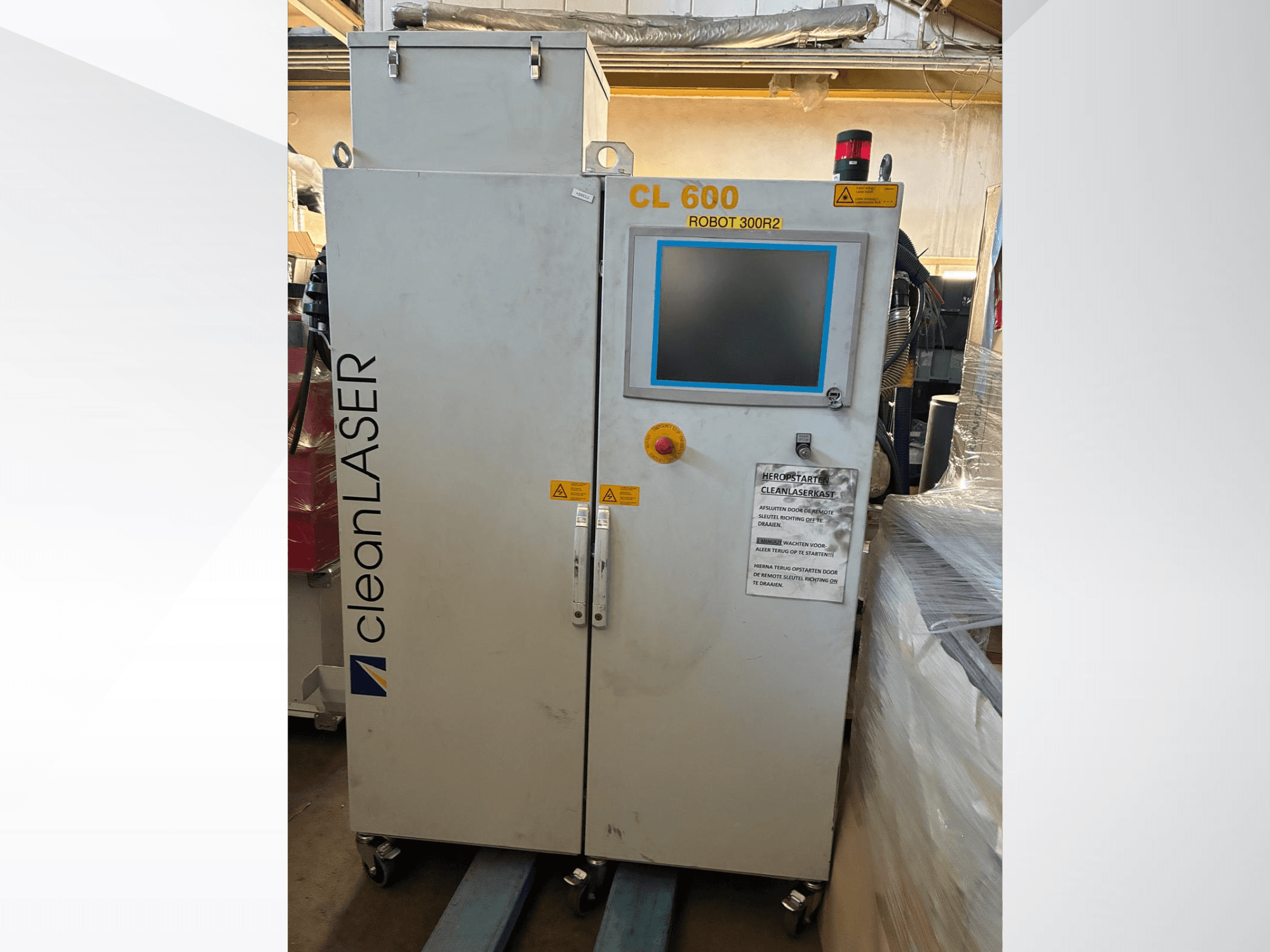 CLEAN LASER CL 600 -automaatiojärjestelmä edestä katsottuna: LCD-näyttö, varoitusmerkinnät ja ohjauspainikkeet ovessa.