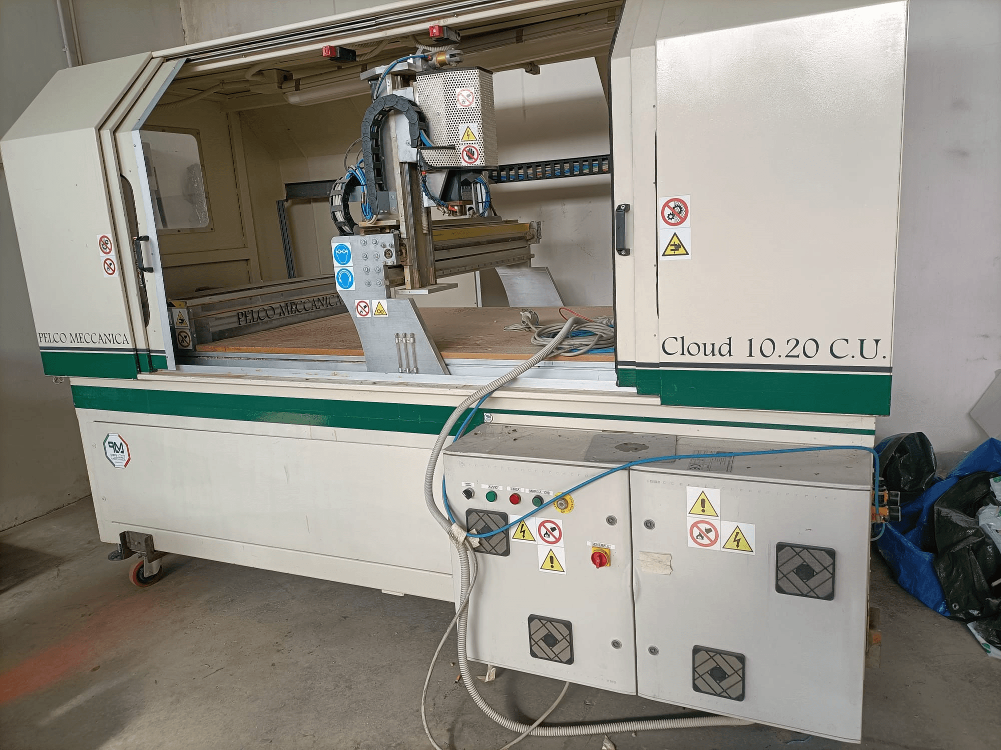 CNC-jyrsin MECCANICA CLOUD 10.20 C.U., etukuva, jossa näkyy ohjauspaneeli ja työtila, turvatarrat ja letkut näkyvissä.