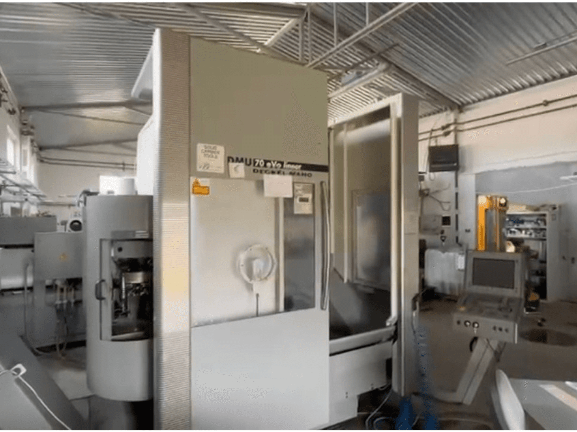 DMU 70 eVo lineaarinen CNC-kone työpajassa, etukuva, jossa on ohjauspaneeli ja moderni muotoilu.