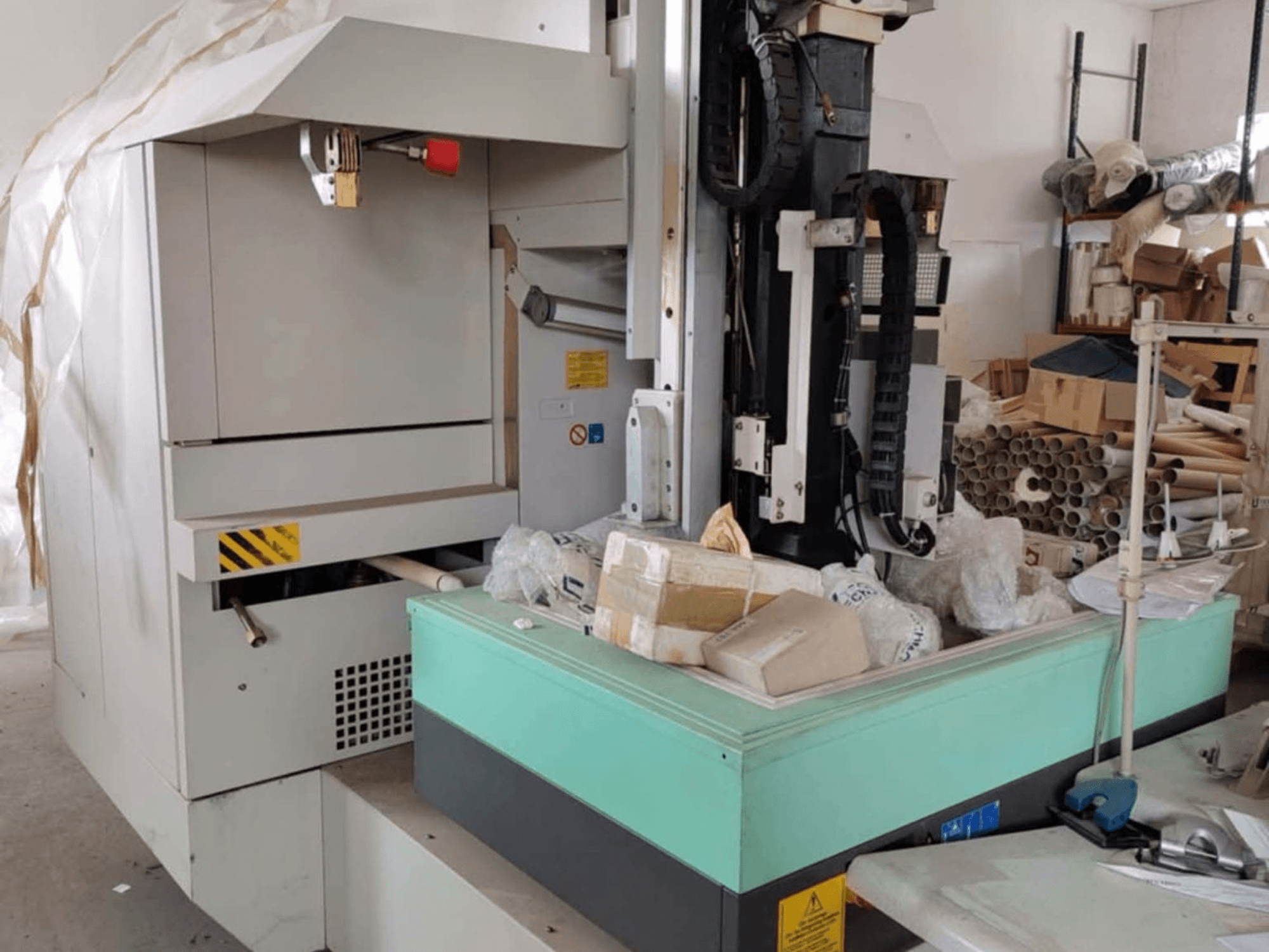 AGIE AGIETRON INTEGRAL 2 -syöpölypuristuskone, etukuva, jossa näkyy ohjauspaneeli, työpöytä ja ympäröivä sotku.