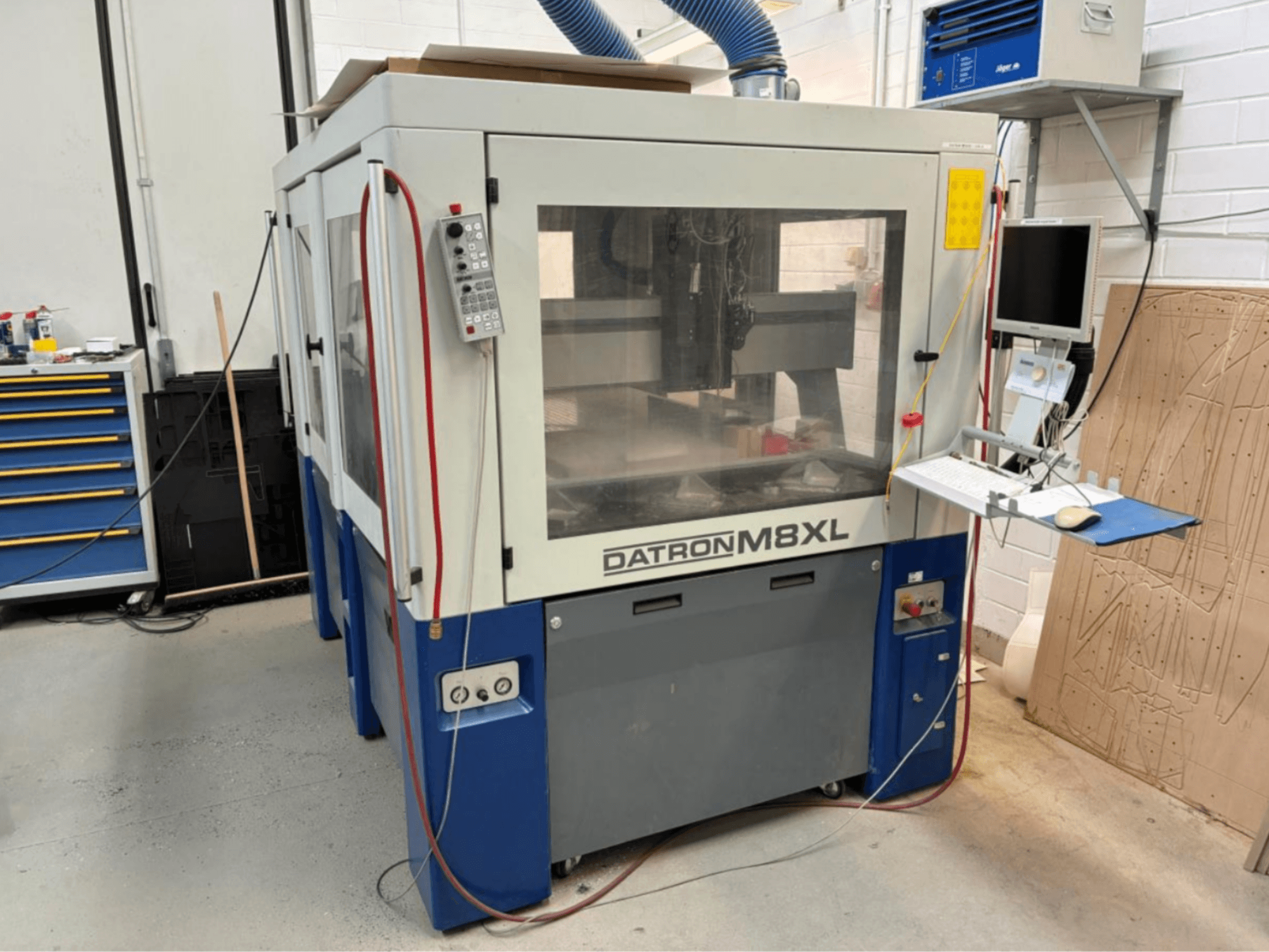 DATRON M8XL CNC-kone työpajassa, etukuva, jossa ohjauspaneeli ja sen viereen asennettu näyttö.