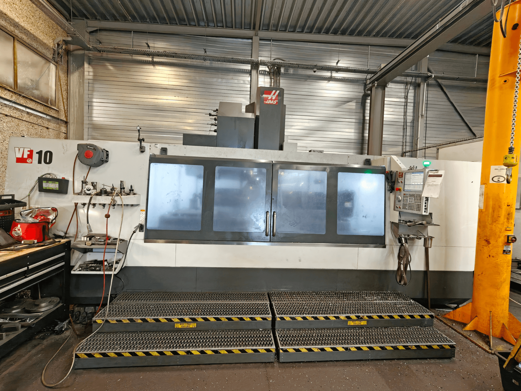 HAAS VF-10/50 -pystykoneistuskeskus, etunäkymä, jossa näkyvät käyttölaitteet ja suuret katseluikkunat.