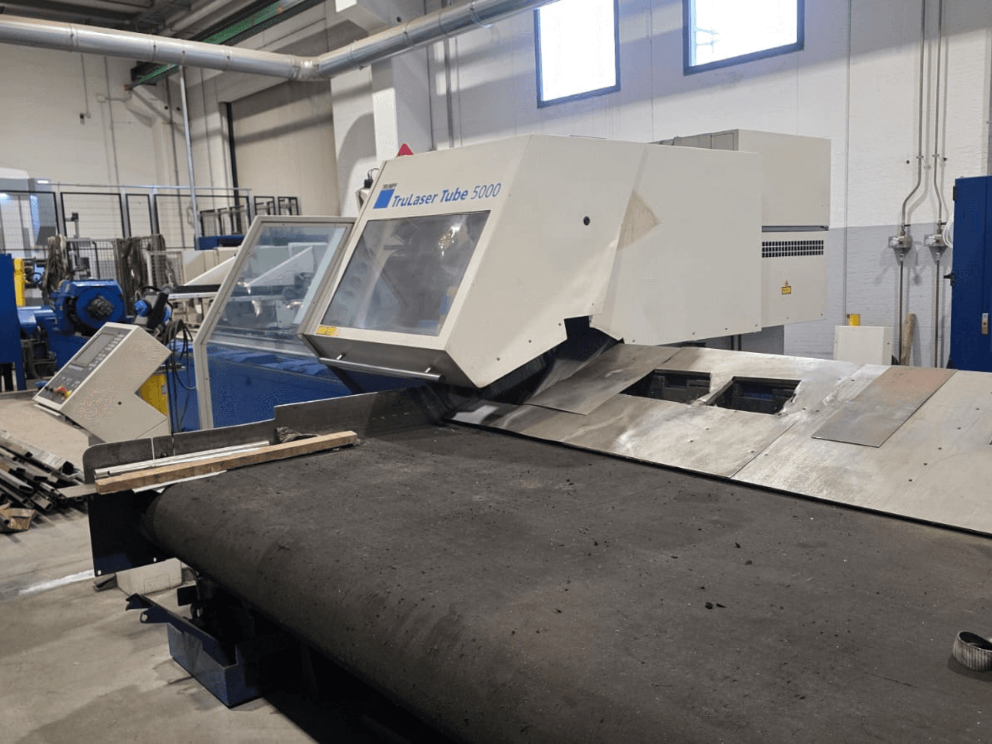 TRUMPF LASERTUBE 5000 -putkenleikkauskone, edestä katsottuna; kuvassa näkyvät leikkausalue ja ohjauspaneeli.