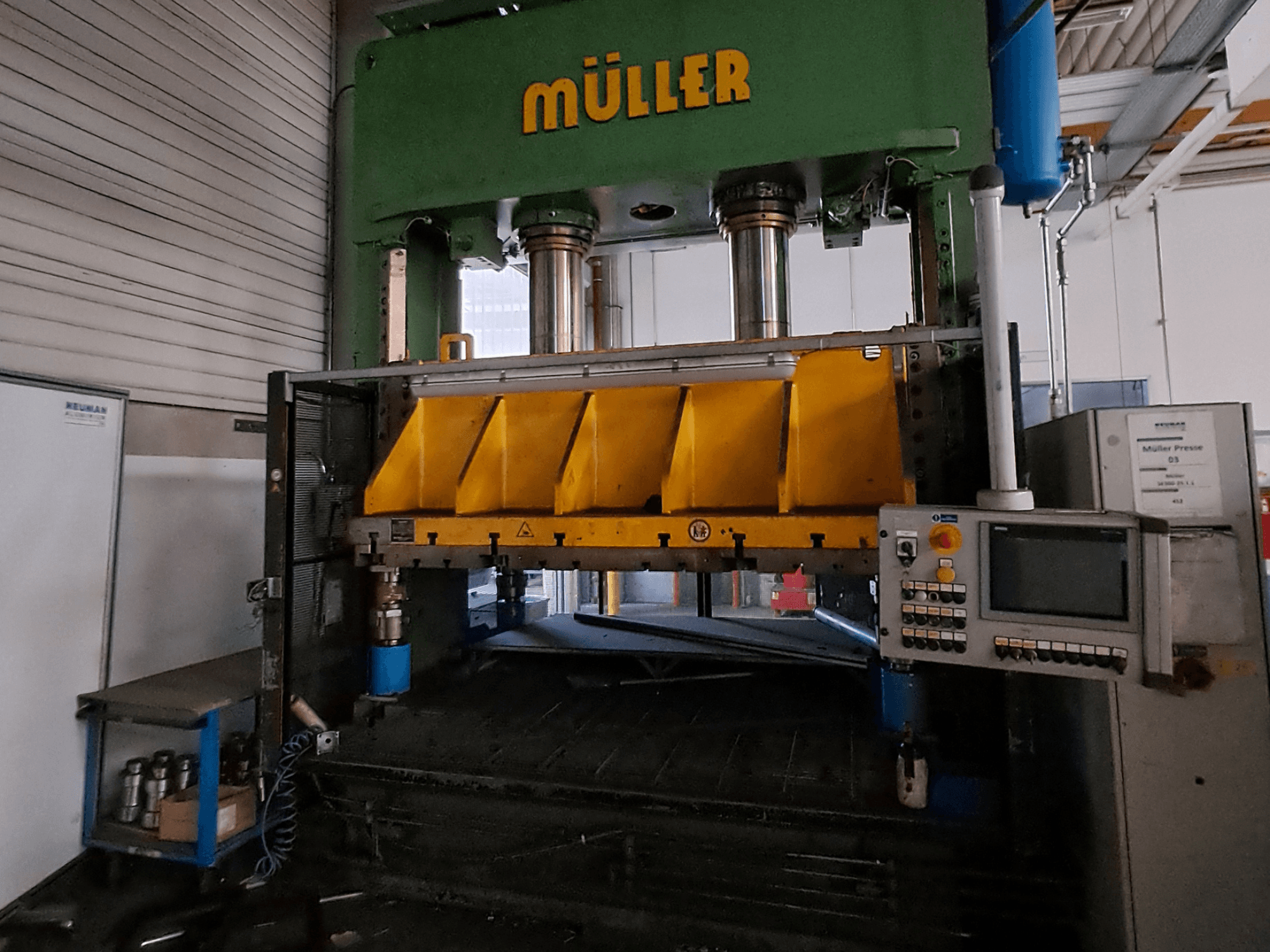 Müller SE 300-25.1.1 -metallipuristimen etunäkymä, jossa näkyvät keltaiset puristusosat ja sivussa oleva ohjauspaneeli.