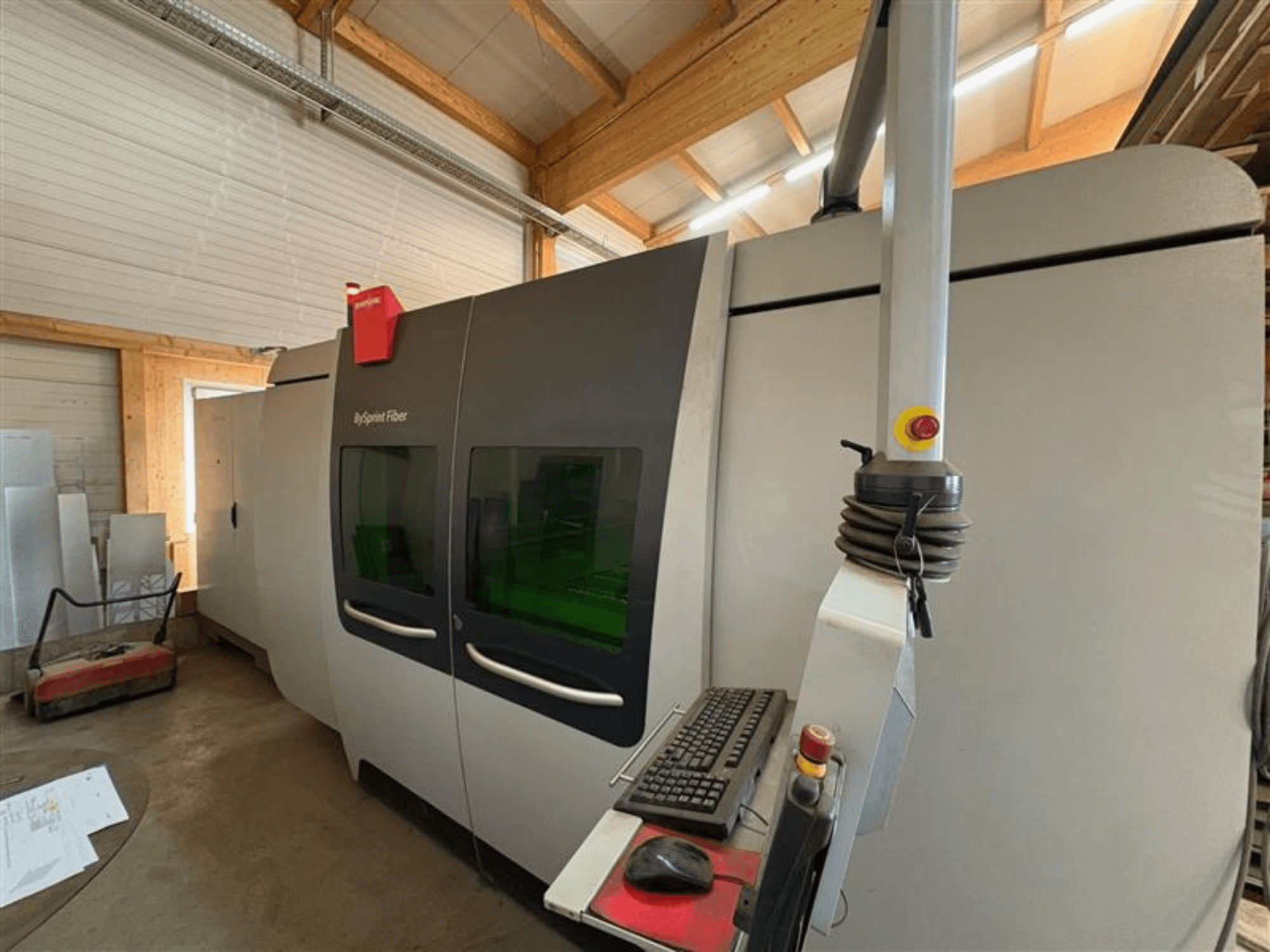 Bystronic ByJet -kuituleikkauskone työpajassa, etukuva, jossa näkyy ohjauspaneeli ja kaksi vihreää katseluikkunaa.