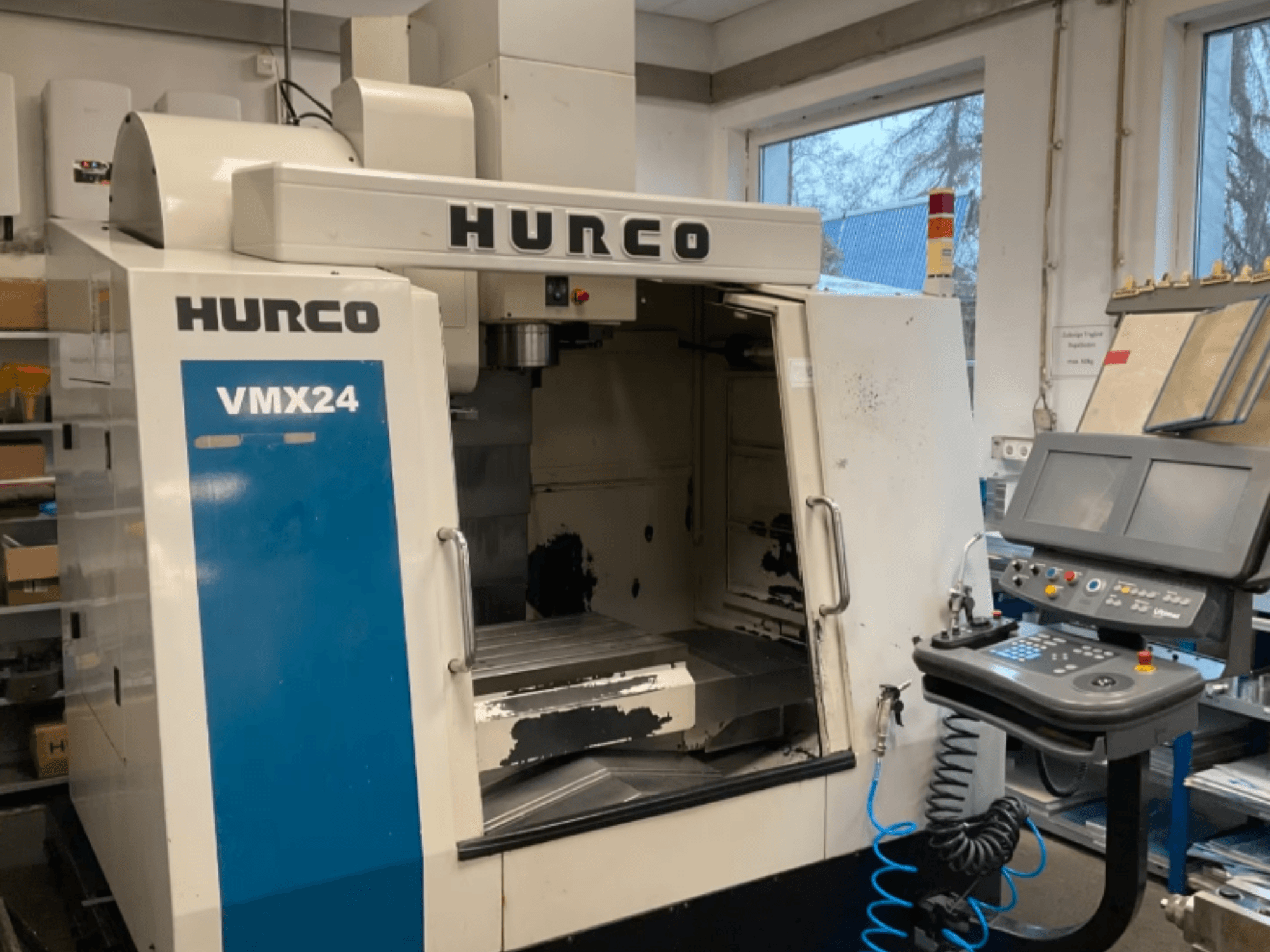 Hurco VMX24 -pystykoneistuskeskus edestä katsottuna; kuvassa näkyvät ohjauspaneeli, karapää ja työstöalue, joissa on havaittavissa kulumisen merkkejä.