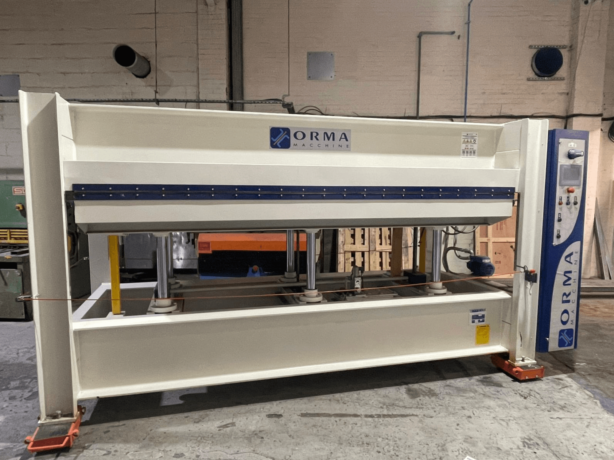 ORMA-koneiston hydraulinen puristin, etukuva, hopeinen viimeistely, ohjauspaneeli oikealla ja pystysuorat männät puristusta varten.