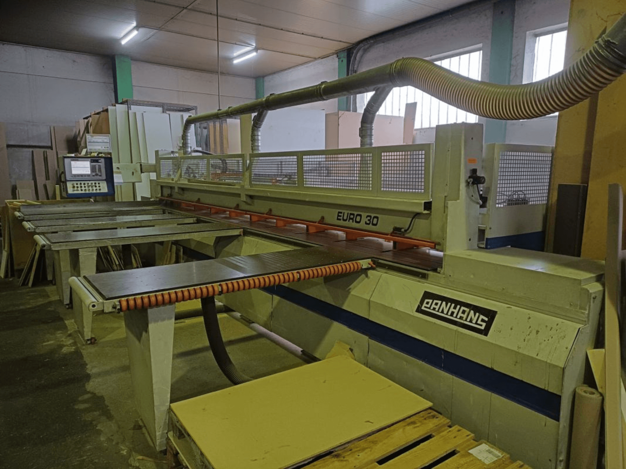 Etukuva PANHANS EURO 30 -levysahasta, jossa on ohjauspaneeli, leikkuupöytä ja pölynpoistoletku työpajassa.