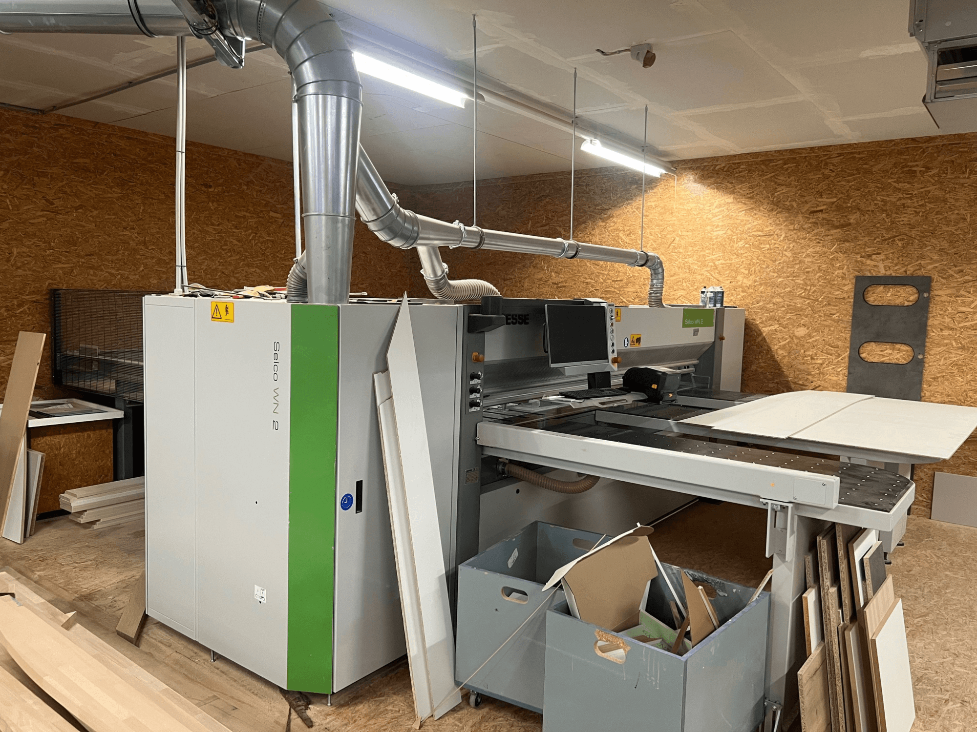 BIESSE Selco WN 2 -levysaha työpajassa, jossa on suuri leikkuupöytä ja pölynpoistojärjestelmä, sivukuva.