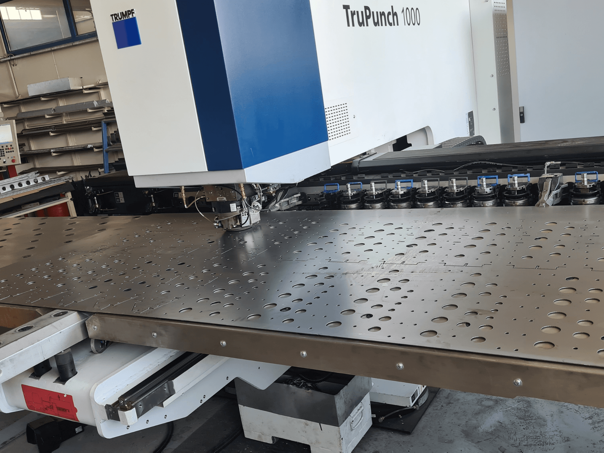 CNC-lävistyskone TRUMPF TruPunch 1000, etunäkymä, jossa näkyy rei'itetty metallilevy ja työkalujen asennus.