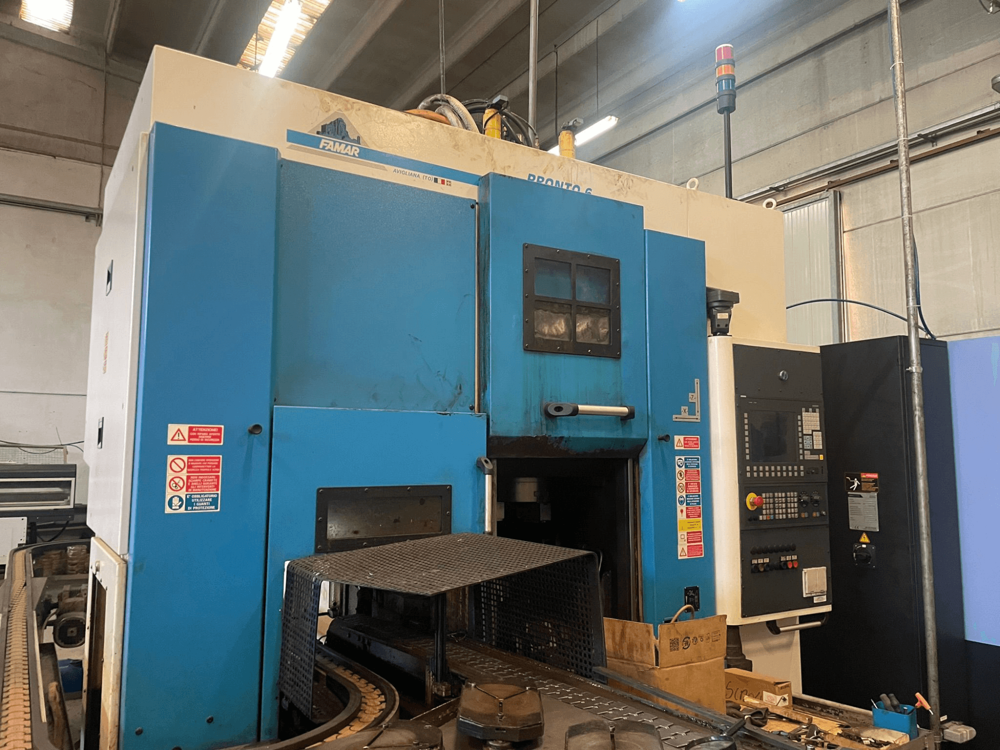 Famar Pronto 6 -pystysorvauskone työpajassa, sivukuva, jossa näkyy ohjauspaneeli, käyttöominaisuudet ja turvatarrat.